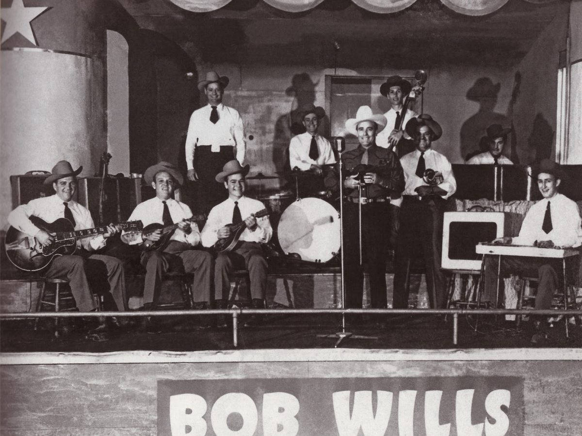 Entertainment 桌布 壁紙 — 一張Bob Wills及其樂隊在舞台上表演的復古黑白照片，戴著牛仔帽並使用樂器。
