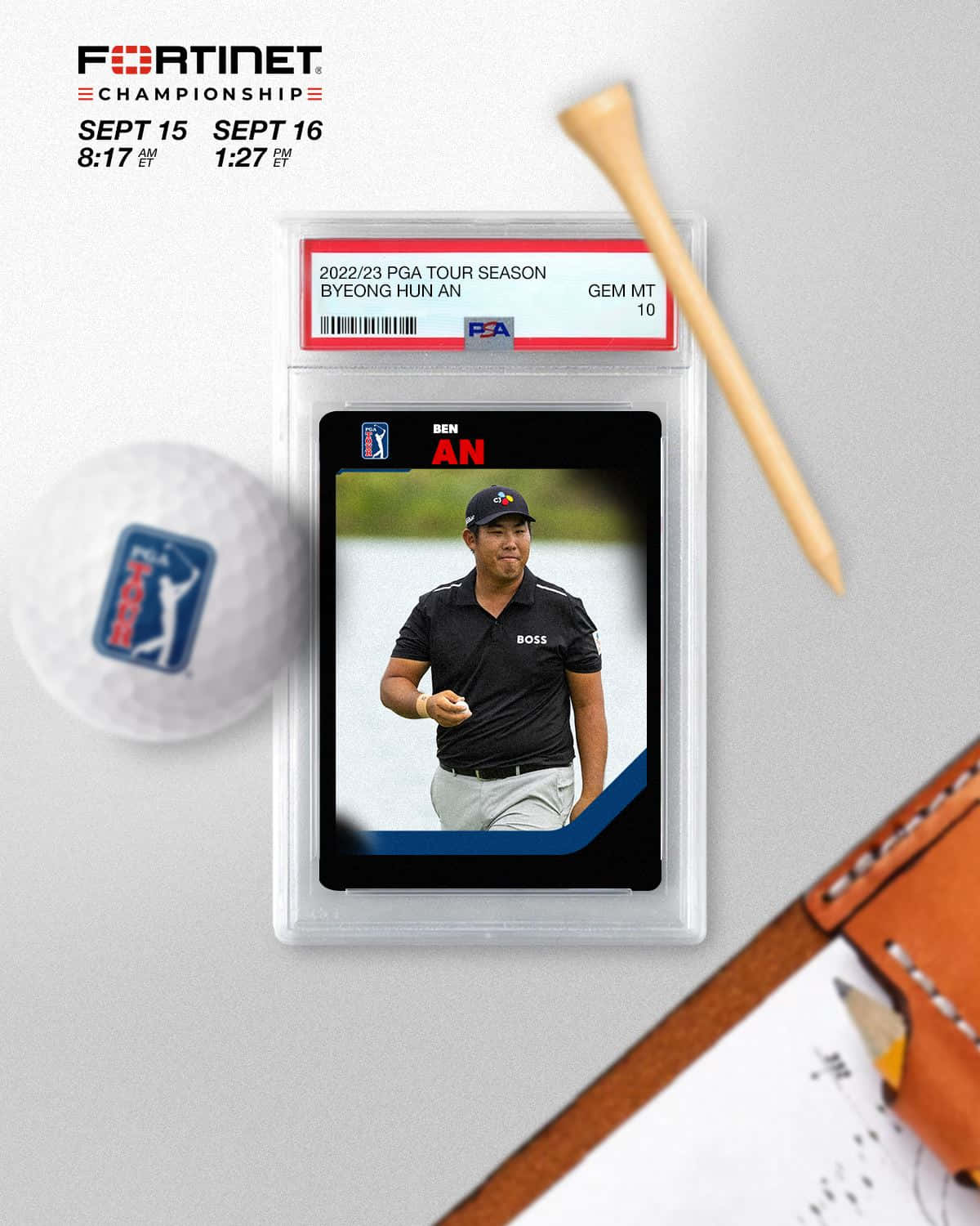 高爾夫 桌布 壁紙 — 一張Byeong Hun An的PGA Tour高爾夫球卡，放在PSA Gem Mint 10保護套內，旁邊有一個高爾夫球和木製球座，置於灰色表面上。
