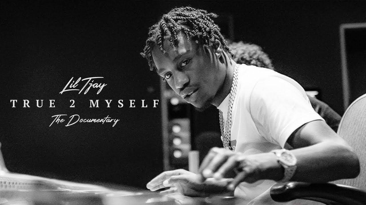 Lil Tjay 桌布 壁紙 — 一張Lil Tjay坐在辦公桌前的黑白肖像，帶有他的紀錄片文字疊加。