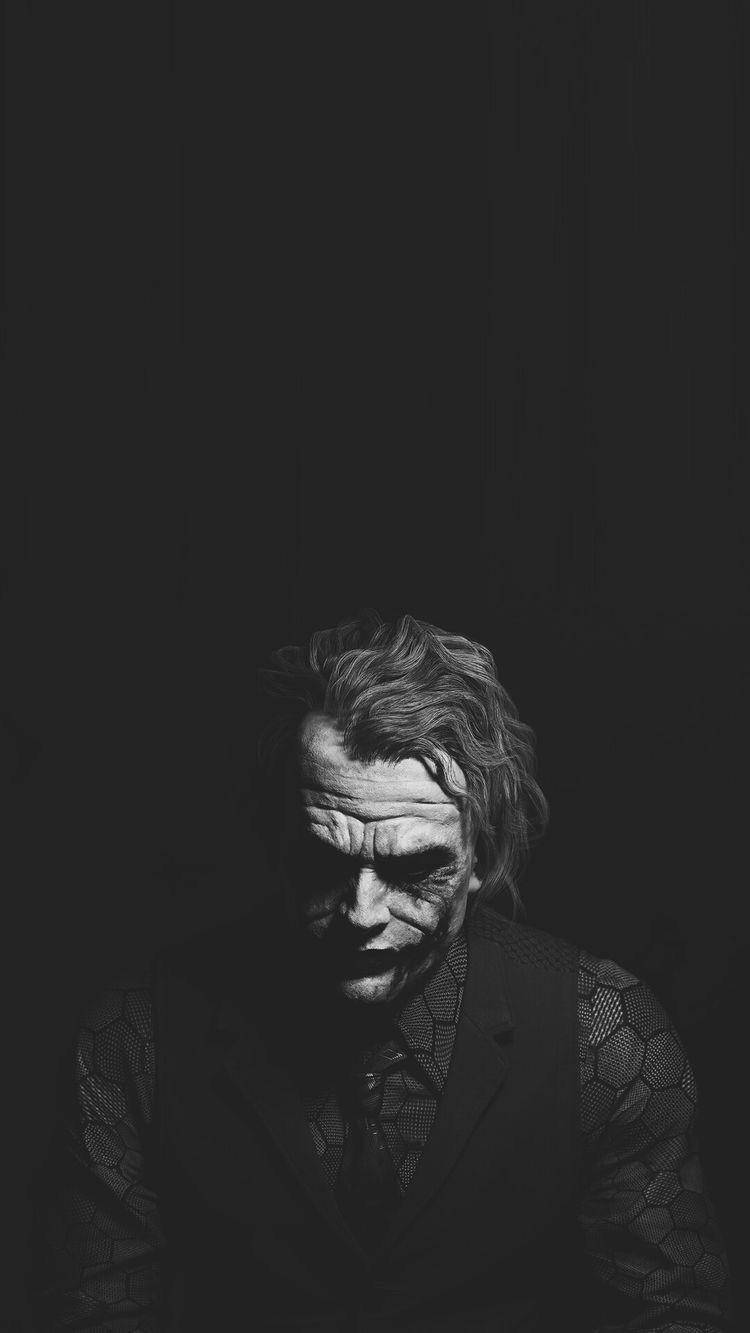 Black And White Joker 桌布 壁紙 — 一張令人毛骨悚然的小丑黑白肖像，在黑暗背景上露出邪惡的笑容。