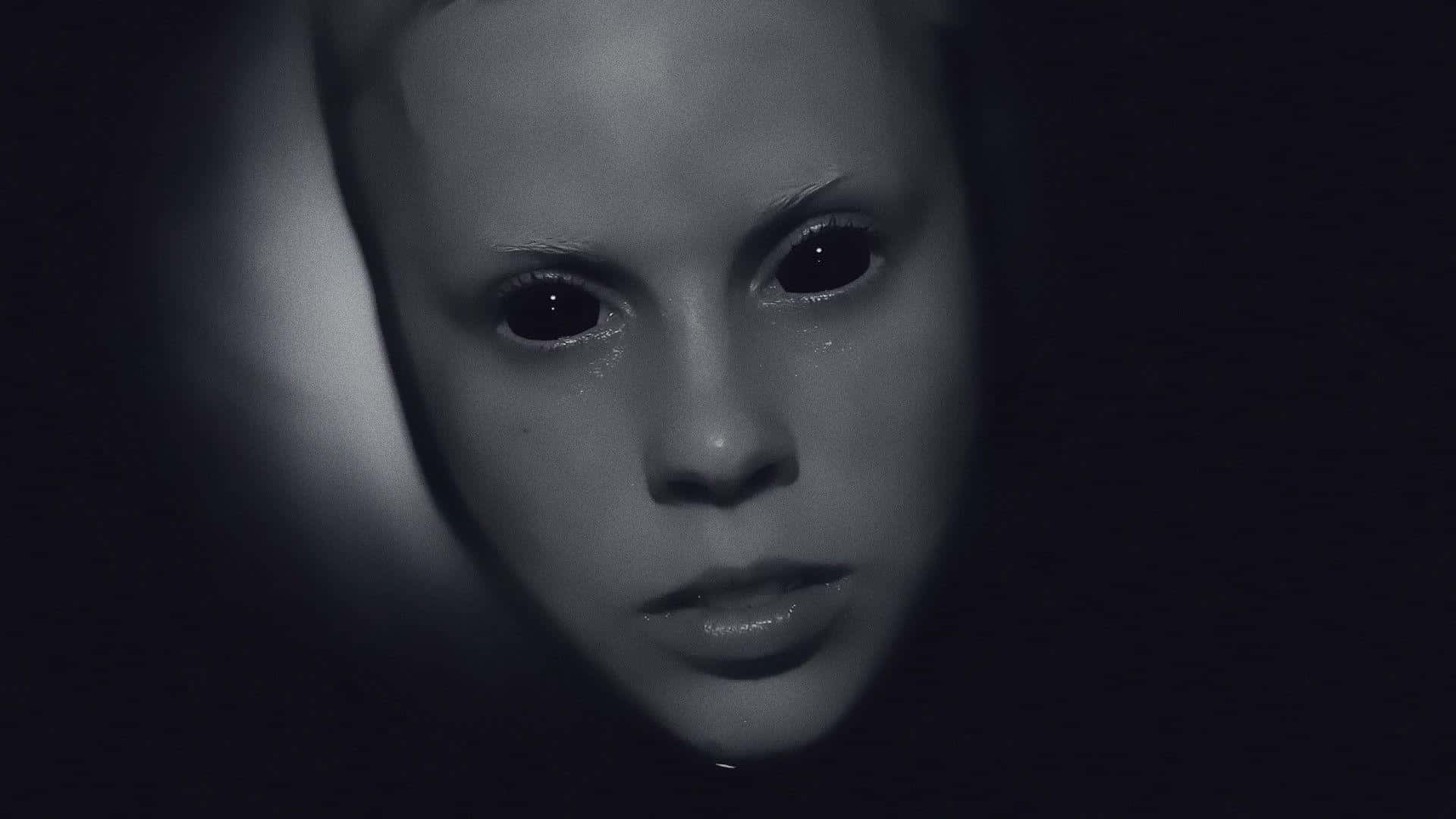 Scary Face 桌布 壁紙 — 一張令人難忘的黑白特寫，孩子的臉在黑暗背景中被單一聚光燈照亮。