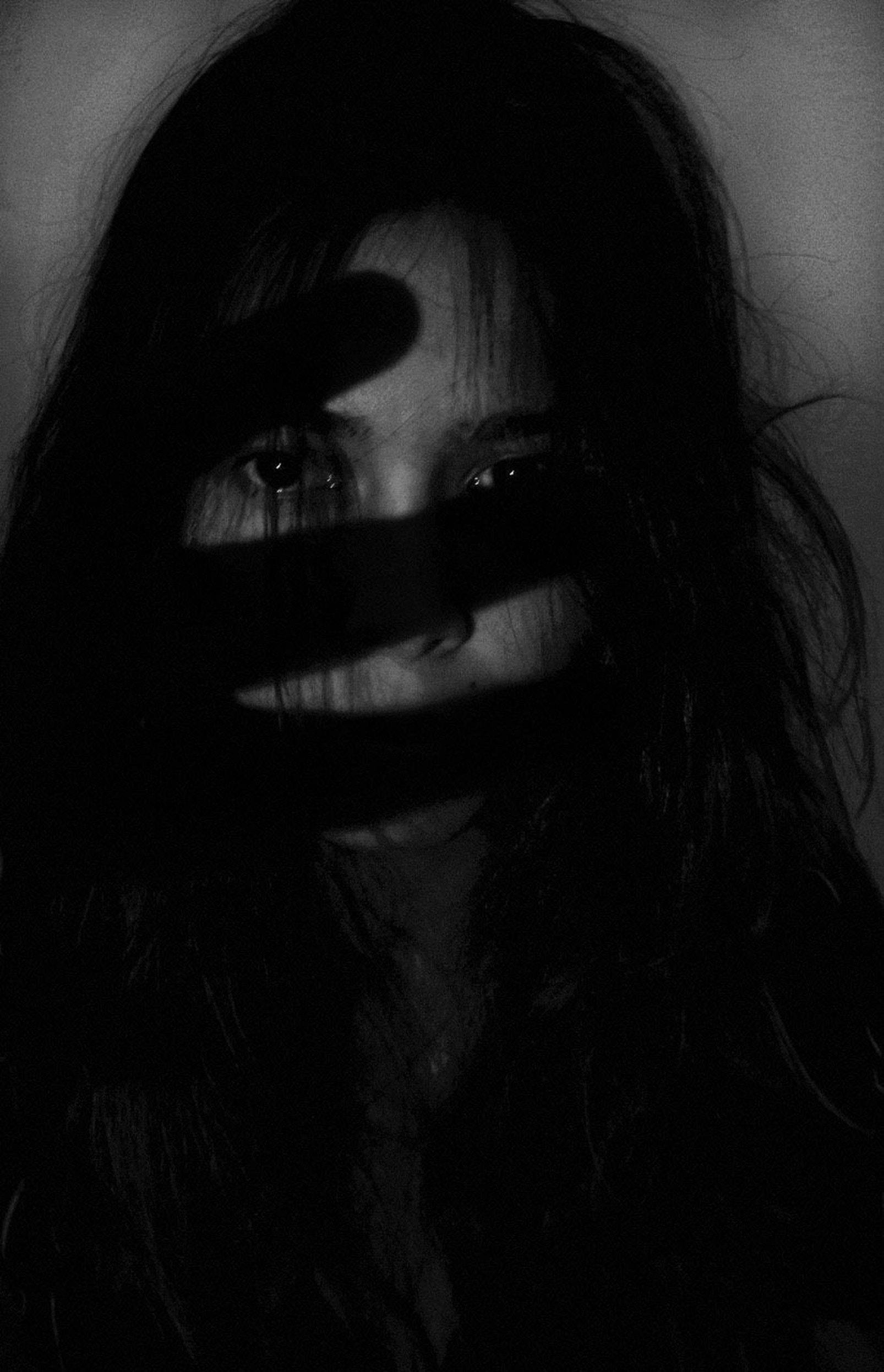 Depression Aesthetic 桌布 壁紙 — 一張令人難忘的黑白肖像照，女人的臉部部分被投射在她五官上的黑暗陰影遮蓋。