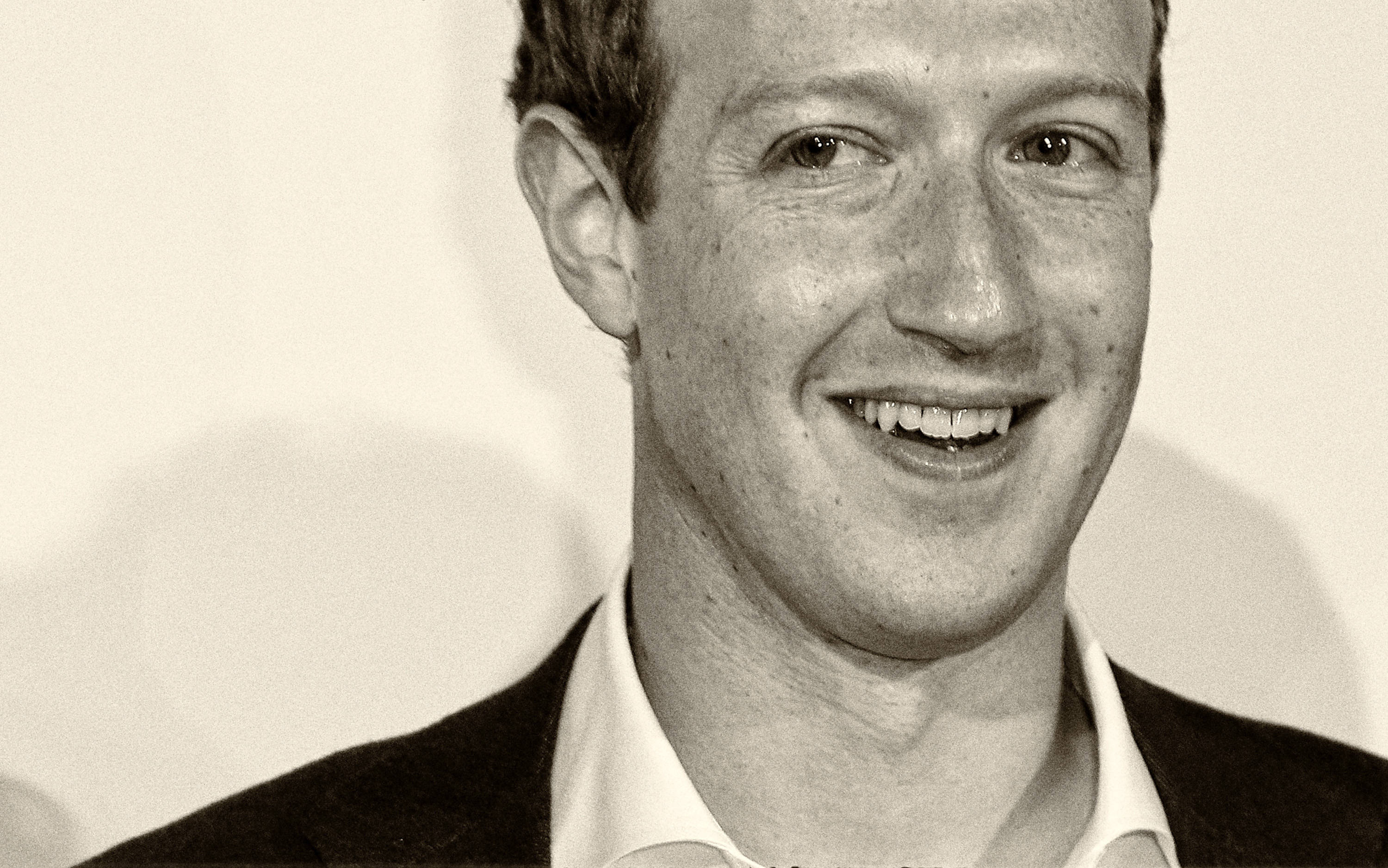 Facebook 桌布 壁紙 — 一張以素色背景為襯托、穿著西裝微笑男士的懷舊棕色調特寫肖像。