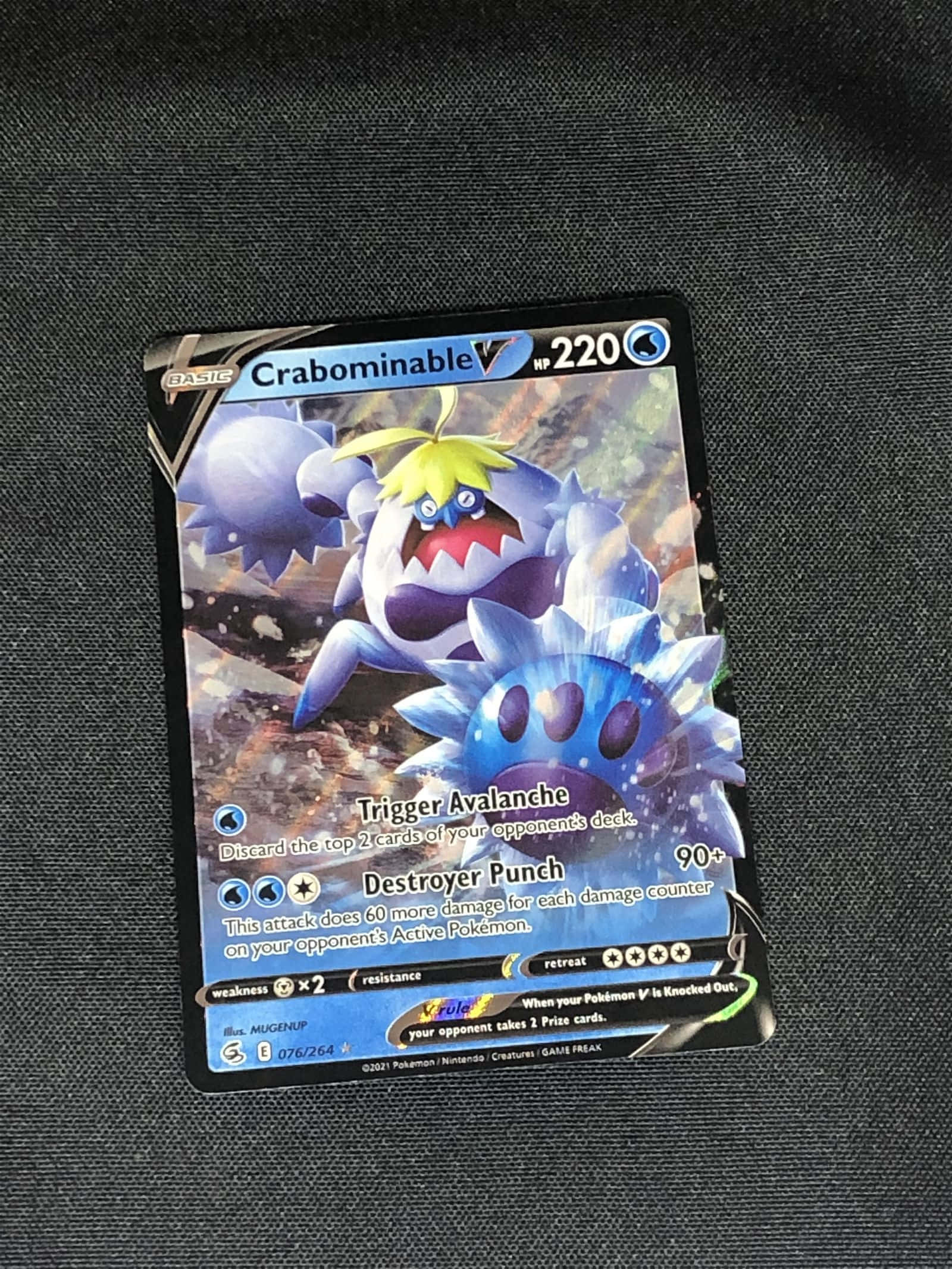 寶可夢 桌布 壁紙 — 一張充滿活力的 Crabominable 寶可夢卡牌放在深色紋理布料表面上。