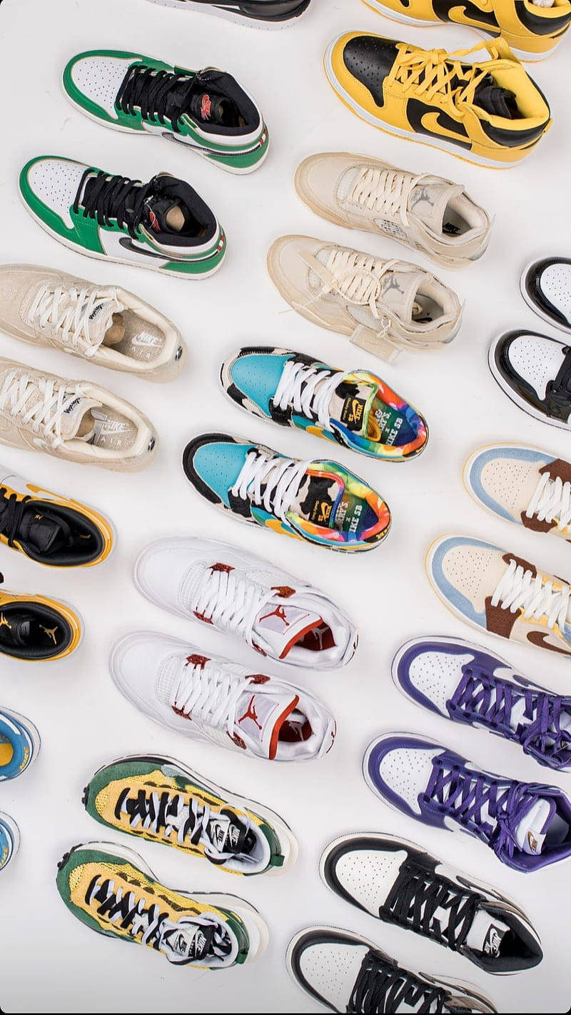 Nike Shoes 桌布 壁紙 — 一張充滿活力的俯拍照片，展示各種色彩繽紛的運動鞋整齊地排列在白色表面上。