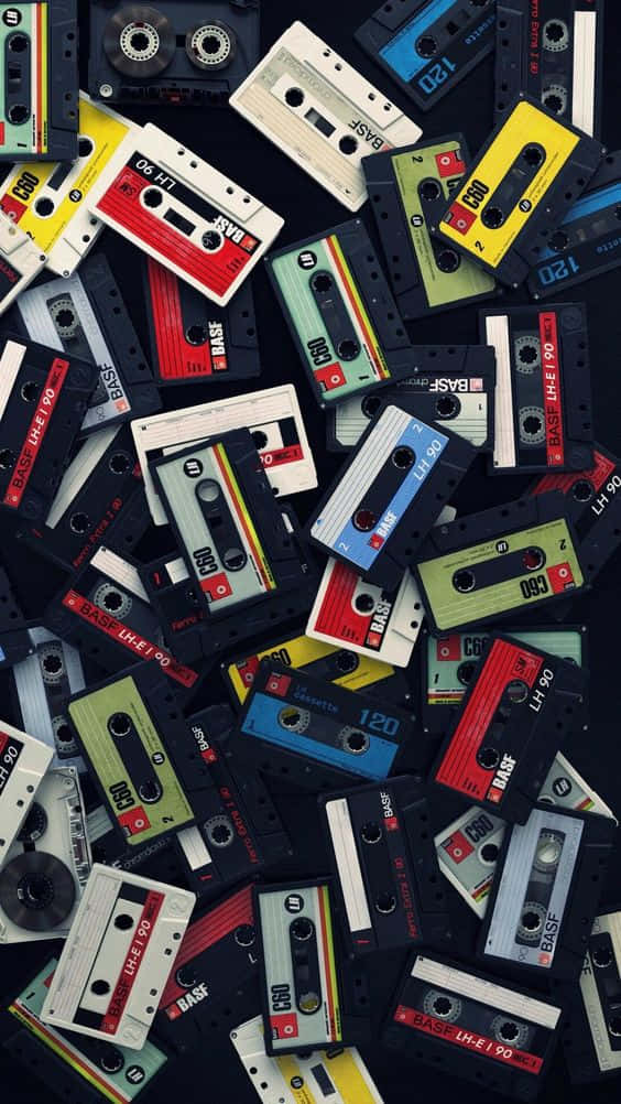 80's 桌布 壁紙 — 一張充滿活力的俯拍照片，展示散落的復古錄音帶，色彩鮮明，背景深色。