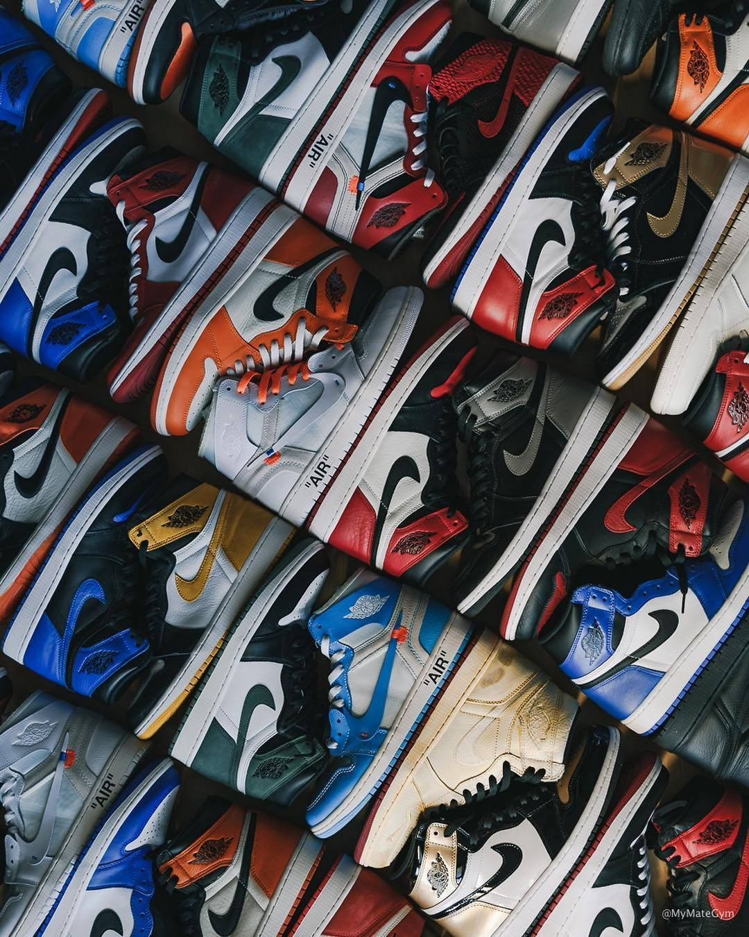 Nike Air Jordan 1 桌布 壁紙 — 一張充滿活力的俯拍照片，展示數十雙色彩繽紛的Nike Air Jordan運動鞋，緊密排列在一個混亂而時尚的展示中。