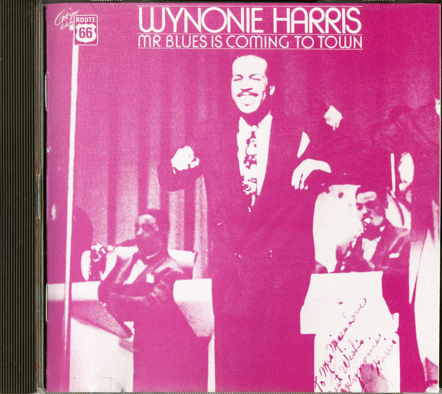 Album Cover 桌布 壁紙 — 一張充滿活力的洋紅色調照片，Wynonie Harris 在明亮的舞台燈光下與穿著西裝的樂隊成員在舞台上表演。