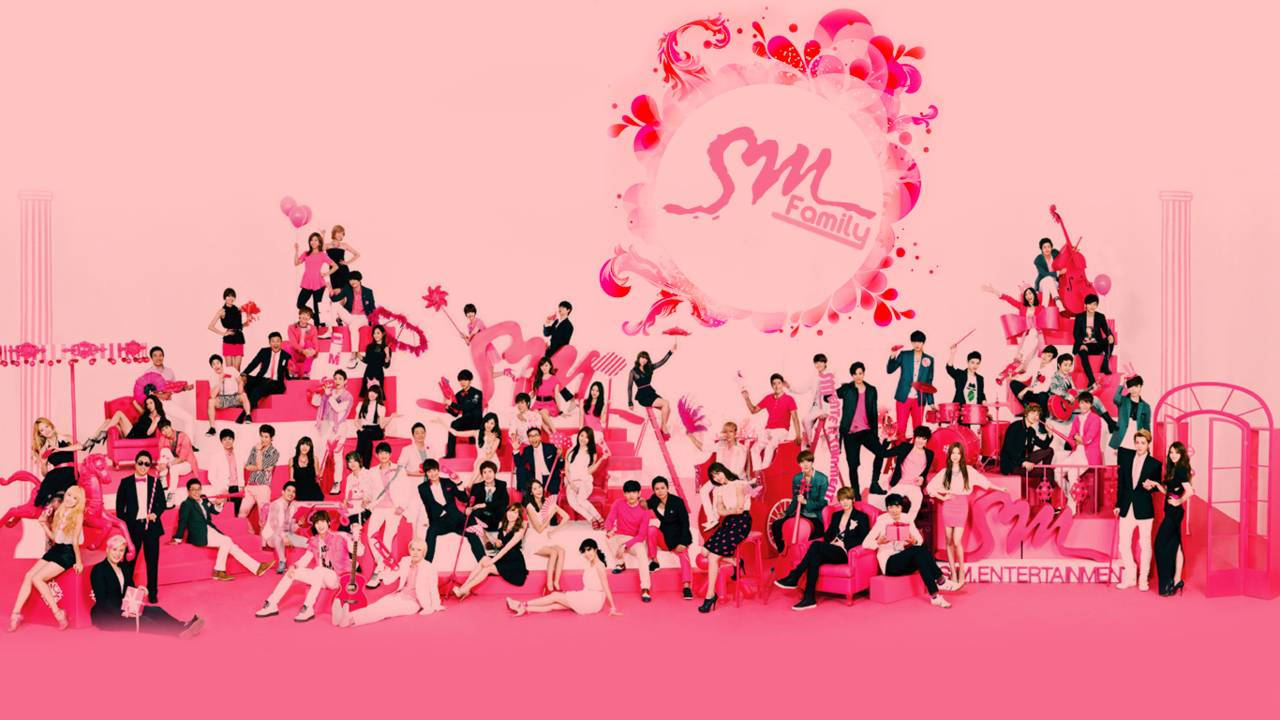 K-pop 桌布 壁紙 — 一張充滿活力的粉紅色工作室照片，許多SM Entertainment藝人在帶有花卉裝飾的雕塑粉紅色佈景中充滿活力地擺姿勢。