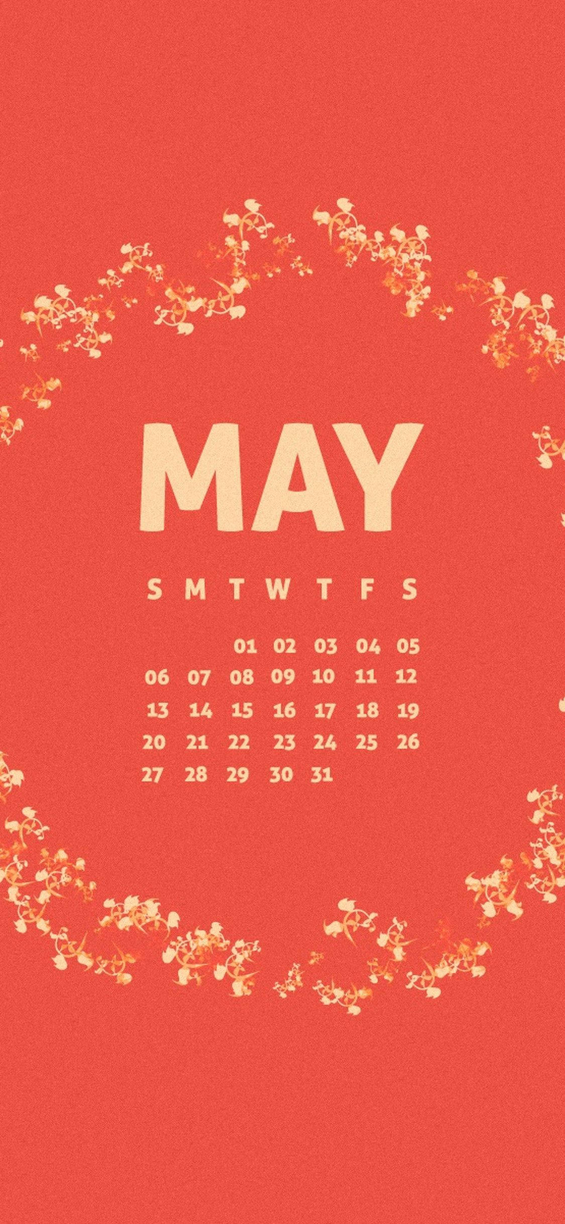 May 桌布 壁紙 — 一張充滿活力的紅色壁紙顯示五月，以粗體奶油色字母呈現，周圍環繞著精緻的花環。