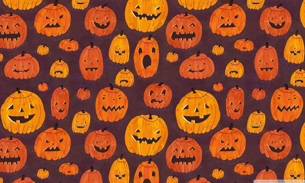 Vintage Halloween 桌布 壁紙 — 一張充滿活力的萬聖節桌布，在深紫色背景上重複出現帶有各種恐怖表情的橙色南瓜燈圖案。