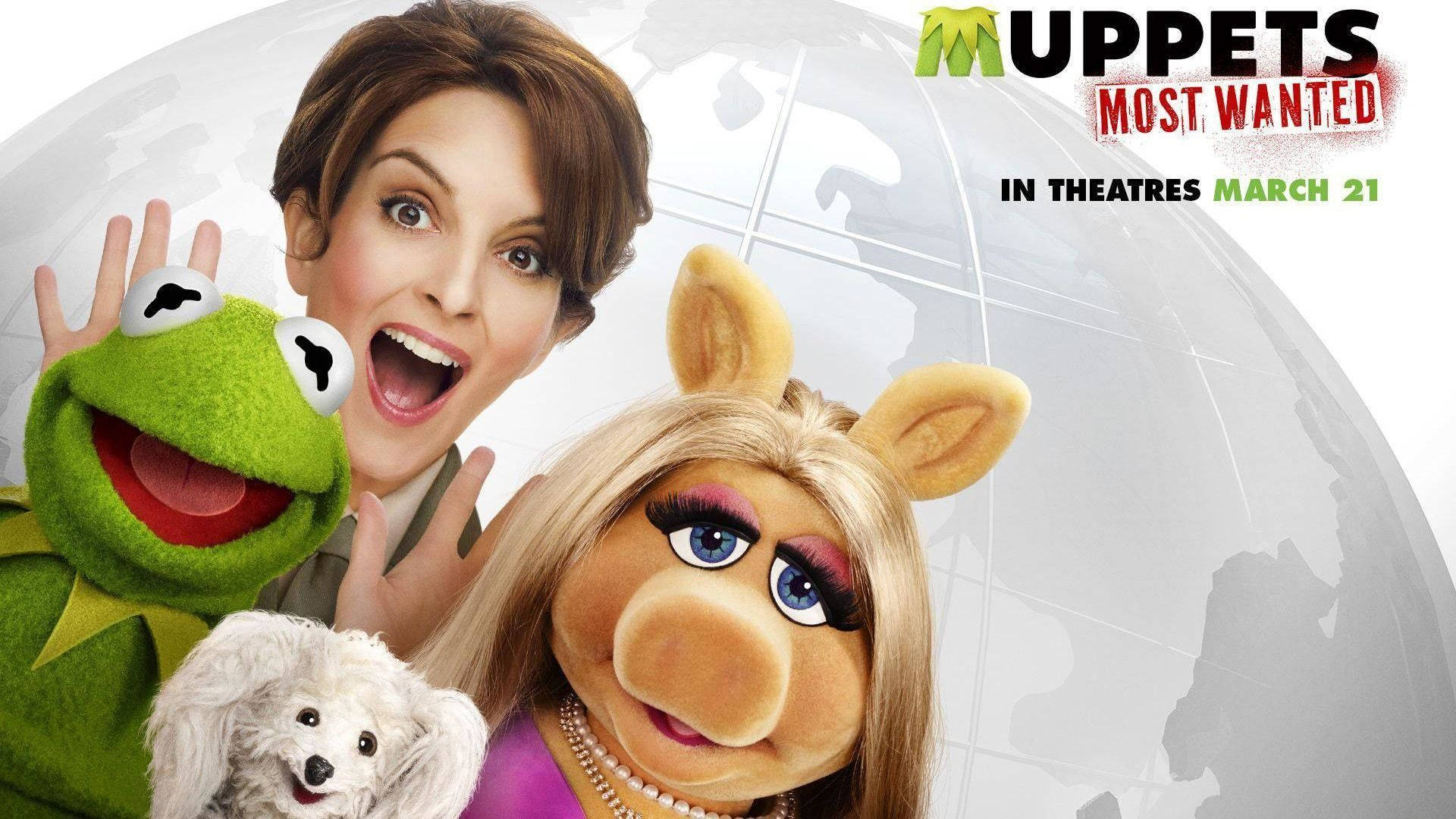Miss Piggy 桌布 壁紙 — 一張充滿活力的電影海報，以青蛙柯密特、豬小姐和一位帶著白色狗的女性為主角，背景為地球儀。