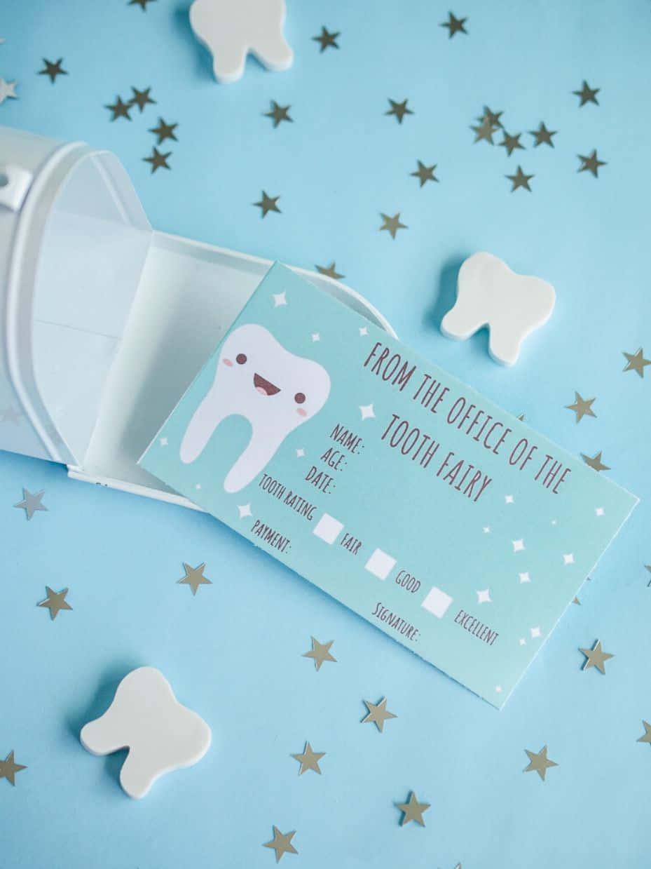 Tooth Fairy 桌布 壁紙 — 一張可愛的牙仙支票，上面有一個微笑的牙齒角色，放在一個白色杯子裡，周圍環繞著白色牙齒形狀和金色星星，背景是淺藍色。