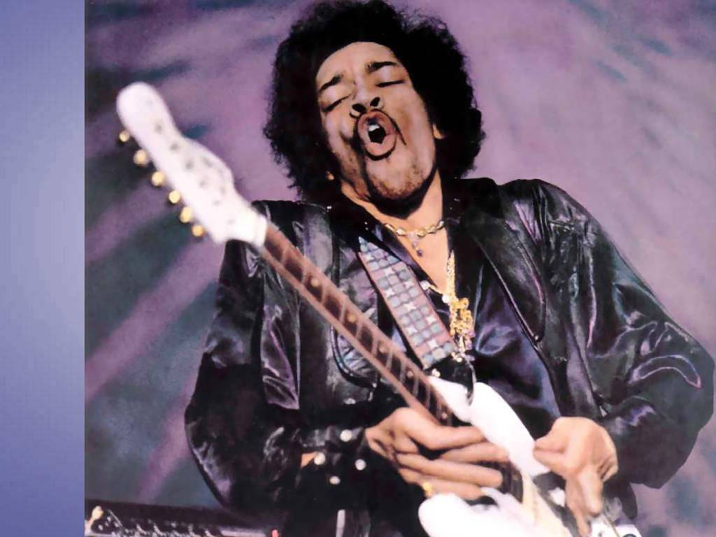 Celebrity 桌布 壁紙 — 一張吉他手Jimi Hendrix在表演中熱情地彈奏白色電吉他，閉著眼睛、張開嘴巴的動態照片。