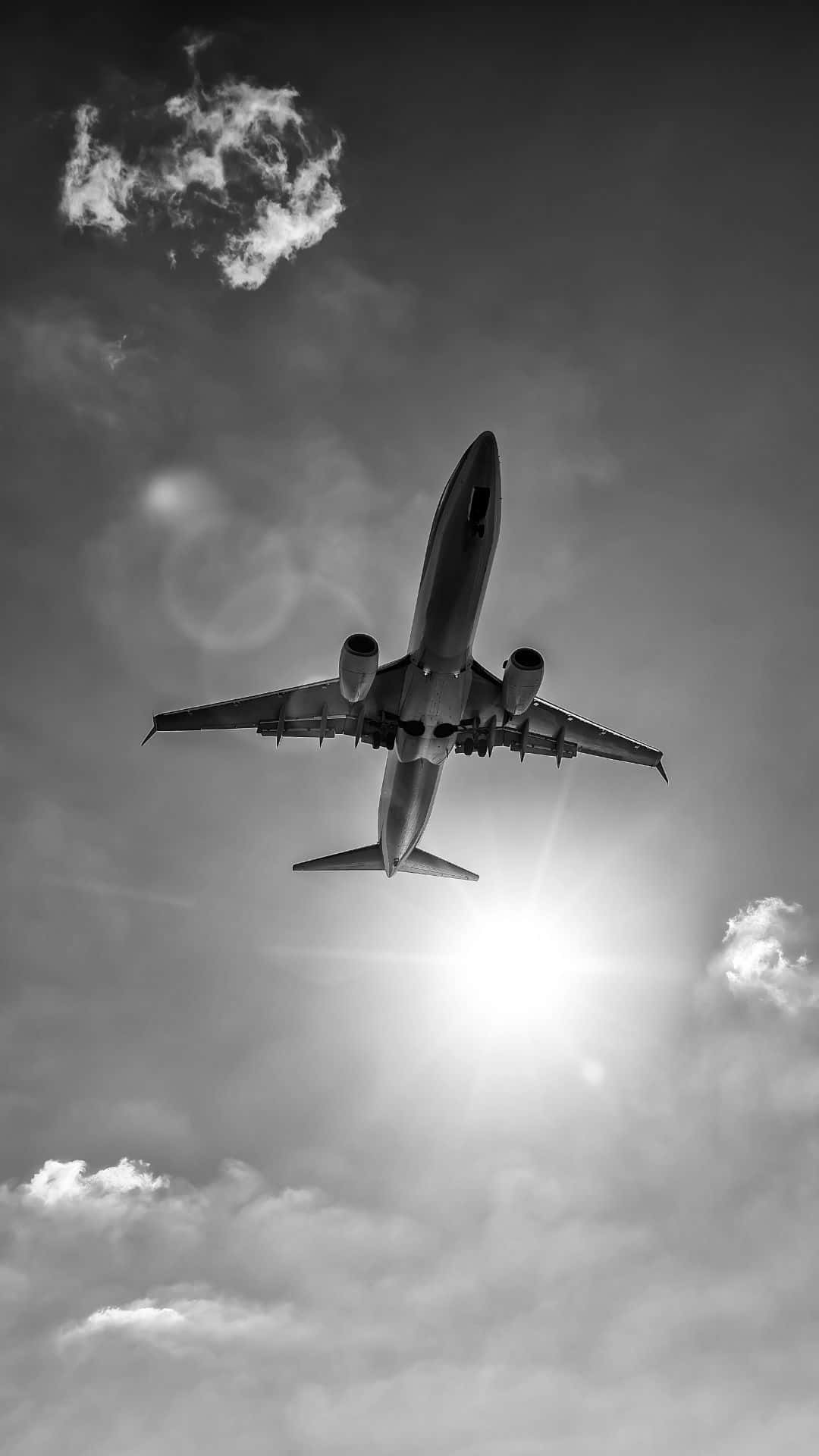 一架商用飛機在頭頂飛過，背後陽光燦爛。 — 飛機 壁紙