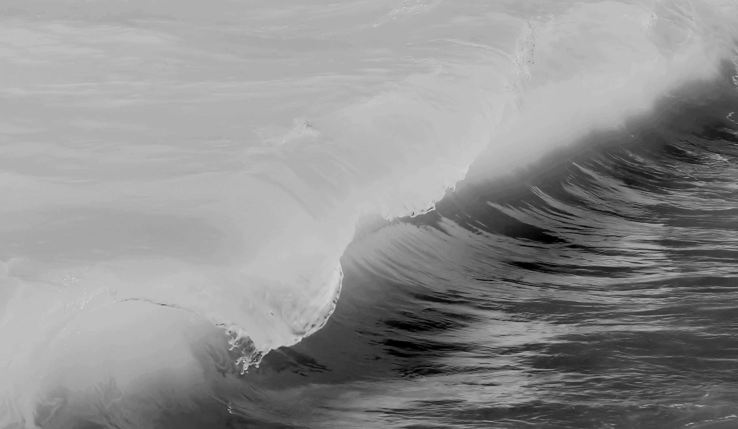 Black And White Ocean 桌布 壁紙 — 一張單色特寫，捕捉強勁海浪在深色海水中翻捲，泛起白色泡沫。