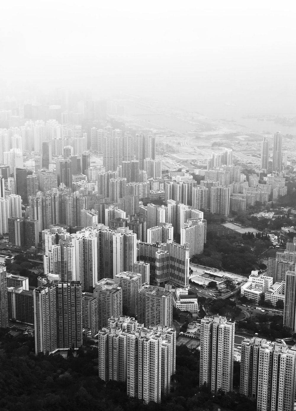 城市 桌布 壁紙 — 一張單色航拍圖，展示密集的城市天際線，高聳的摩天大樓逐漸融入大氣霧霾中。