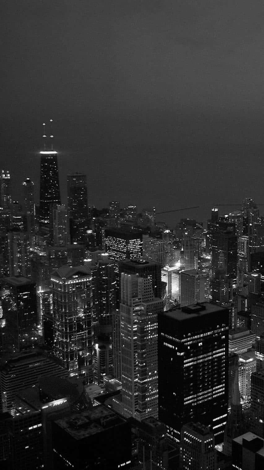 Aesthetic Dark 桌布 壁紙 — 一張單色鳥瞰圖，展現密集的城市夜景，發光的摩天大樓刺穿黑暗的天空。