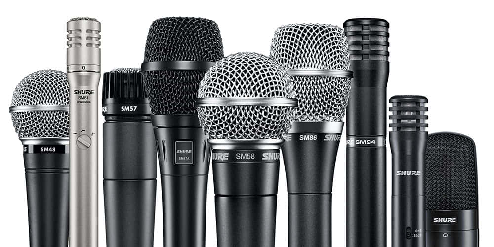 Microphones 桌布 壁紙 — 一張在乾淨白色背景上排列各種Shure麥克風型號的攝影棚照片。