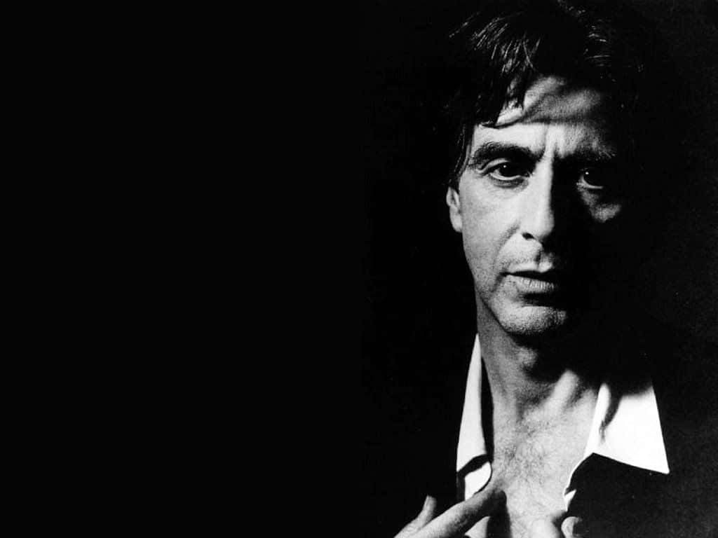 Al Pacino 桌布 壁紙 — 一張在深色背景下，眼神銳利、臉部帶有陰影的男士黑白肖像。