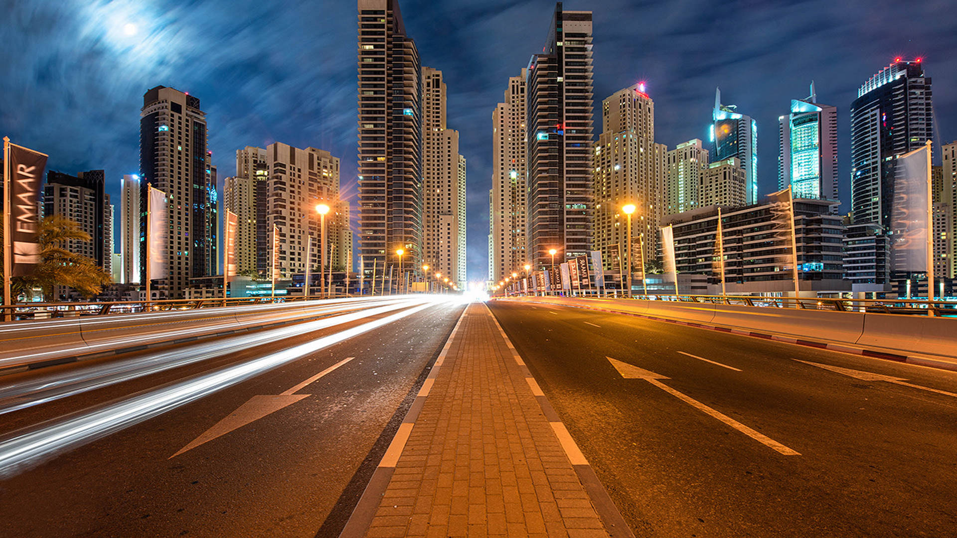 月光下，城市高速公路夜景，車燈光軌和明亮的摩天大樓。 — Google Meet 壁紙