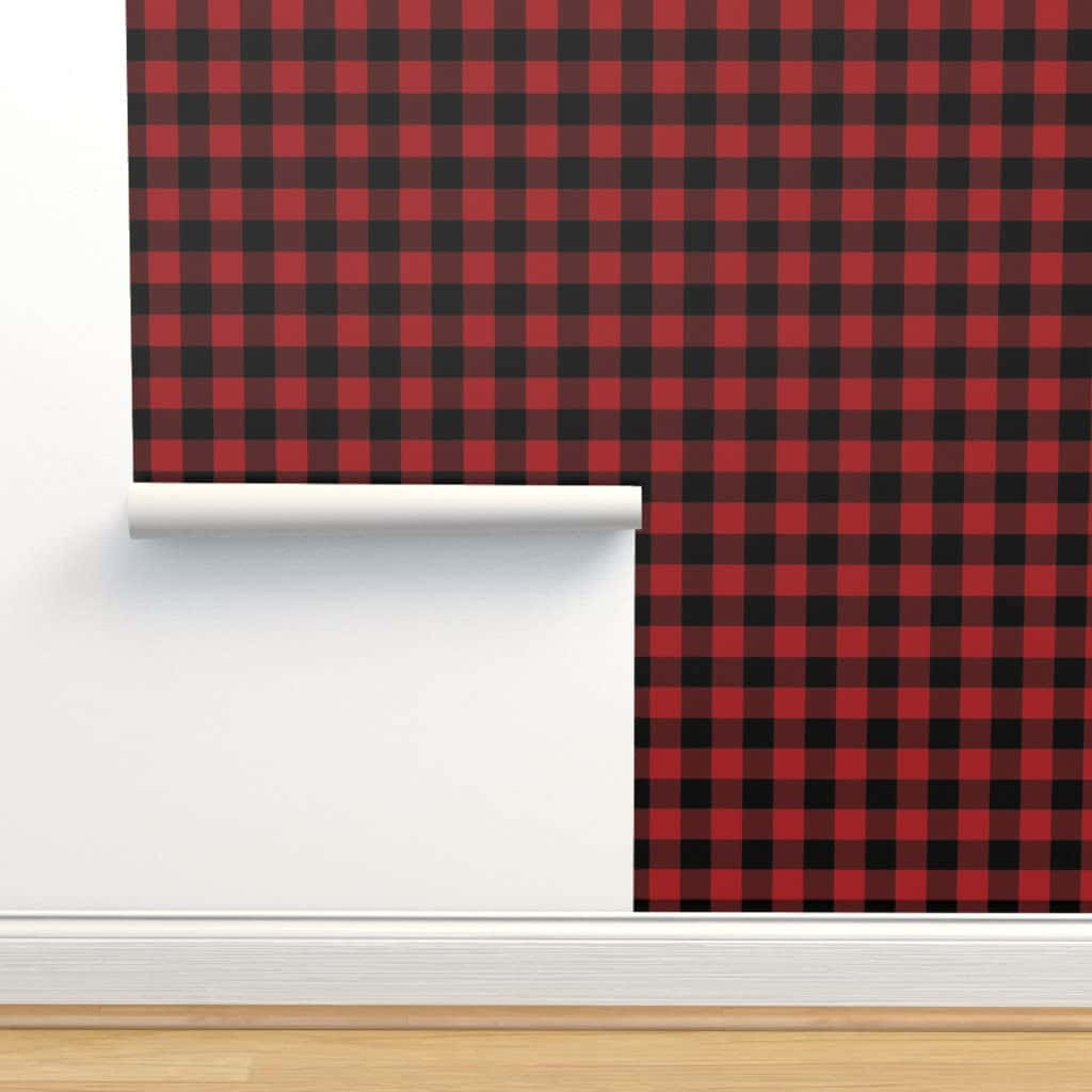 Black And Red Plaid 桌布 壁紙 — 一張大膽的紅黑 buffalo 格紋壁紙被剝開，露出淺色木地板上潔白的牆角。