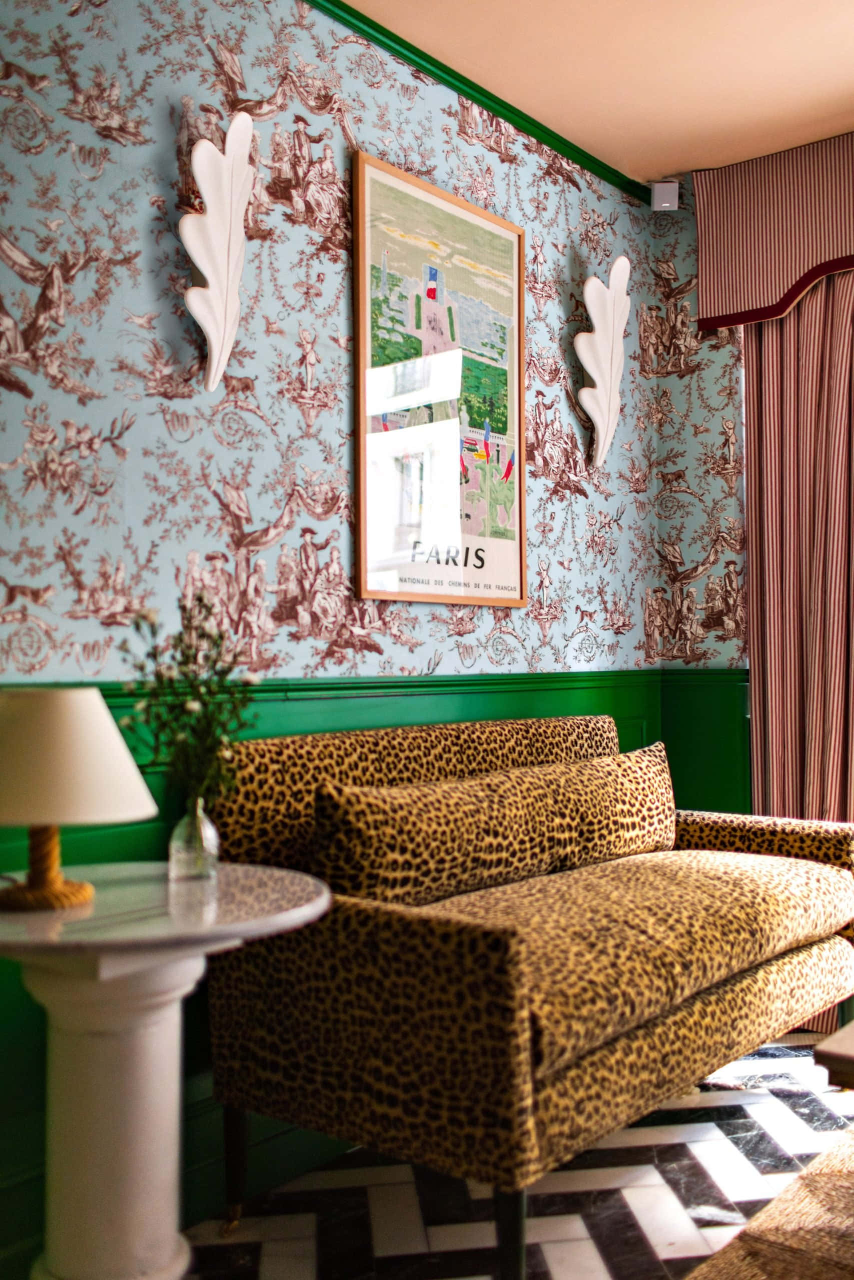 Interior Design 桌布 壁紙 — 一張大膽的豹紋沙發放在一個充滿活力的房間裡，房間有藍色托伊爾壁紙、綠色飾邊和黑白棋盤格地板。