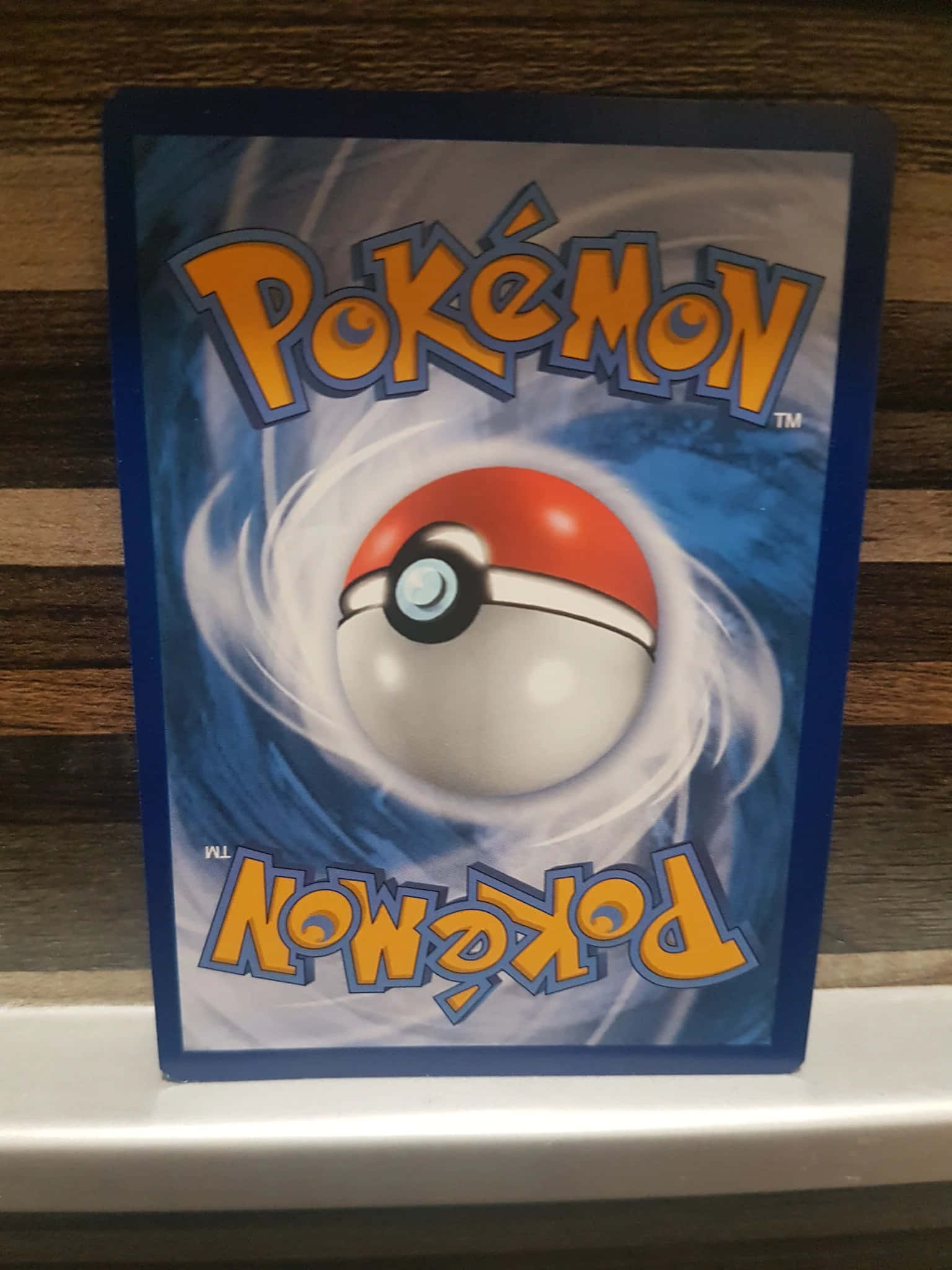 Pokemon Card 桌布 壁紙 — 一張寶可夢卡牌，特色是紅白相間的寶可夢球在藍色能量中旋轉，背景充滿動感。