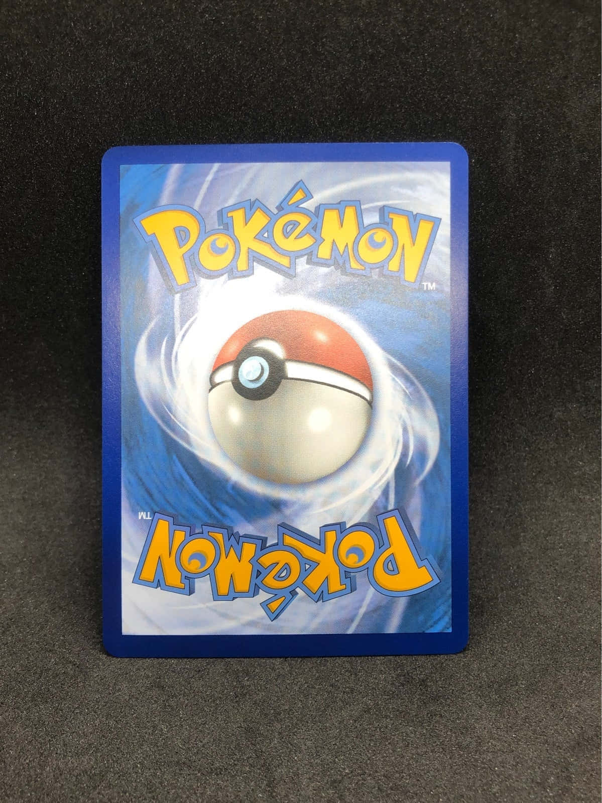 Pokemon Card 桌布 壁紙 — 一張寶可夢集換式卡牌，在深色紋理背景上，精靈球在藍色能量中旋轉發光。