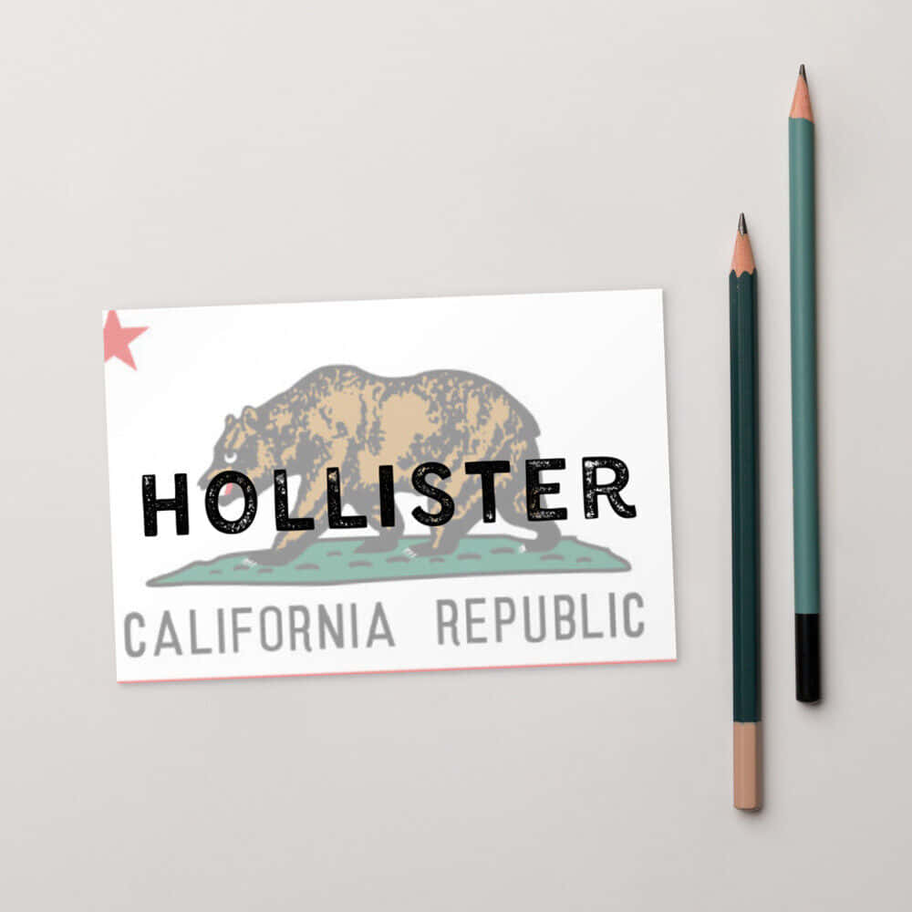 hollister 桌布 壁紙 — 一張帶有熊圖案和California Republic文字的Hollister品牌卡，放在中性灰色表面上，旁邊有兩支彩色鉛筆。