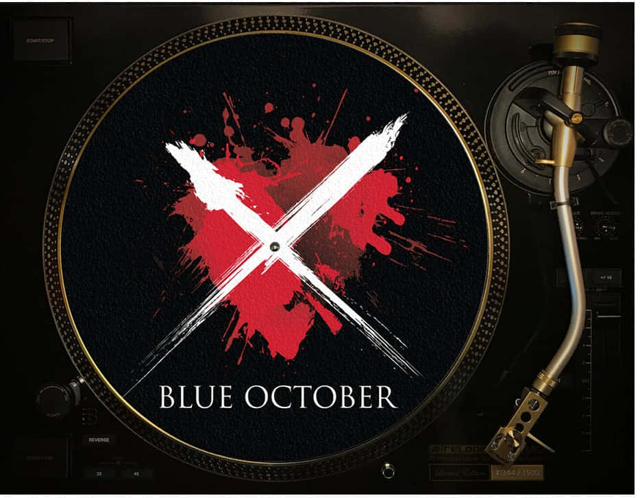 Blue October 桌布 壁紙 — 一張帶有醒目紅白潑濺設計的黑膠唱片在帶有金色裝飾的黑色唱盤上旋轉。