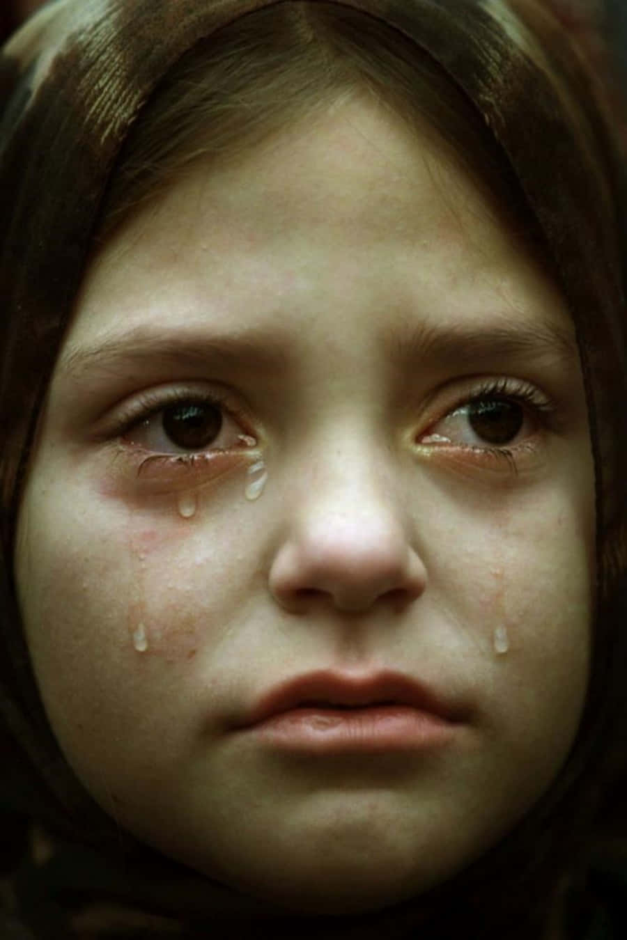 Emotional 桌布 壁紙 — 一張年輕女孩在柔和昏暗燈光下淚流滿面的特寫照片。