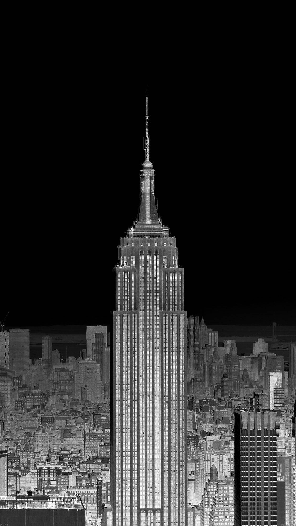 New York 桌布 壁紙 — 一張引人注目的黑白夜景照片，帝國大廈高聳於紐約市密集的天際線之上。