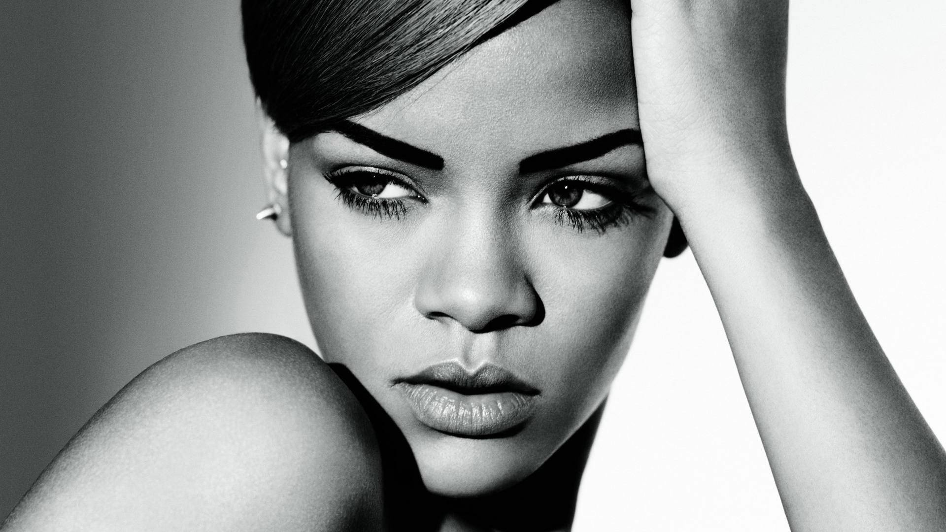 黑白 桌布 壁紙 — 一張引人注目的黑白肖像，Rihanna 一手放在頭上，凝視著鏡頭。