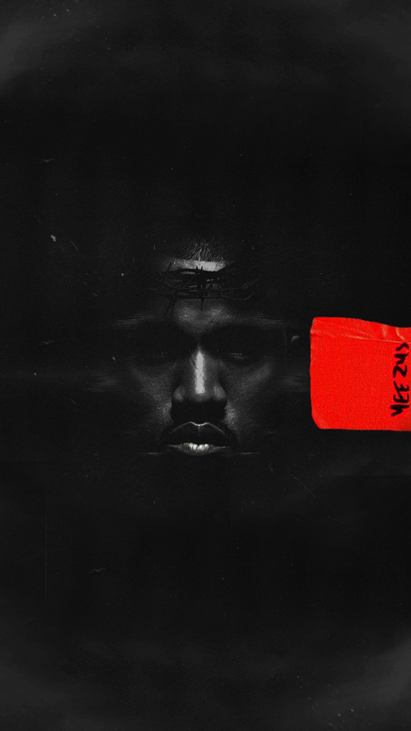 Kanye West 桌布 壁紙 — 一張強烈的黑白肖像，男人的臉部分被陰影遮擋，一隻眼睛上貼著一張大膽的紅色貼紙。