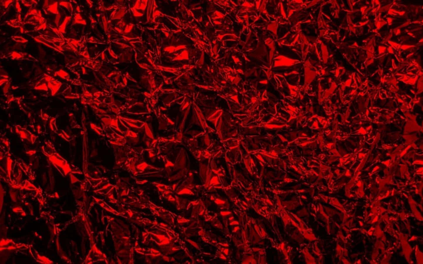 Red Texture 桌布 壁紙 — 一張強烈皺褶的紅色金屬箔片特寫，帶有銳利的高光和深邃的陰影，營造出有紋理且反光的表面。