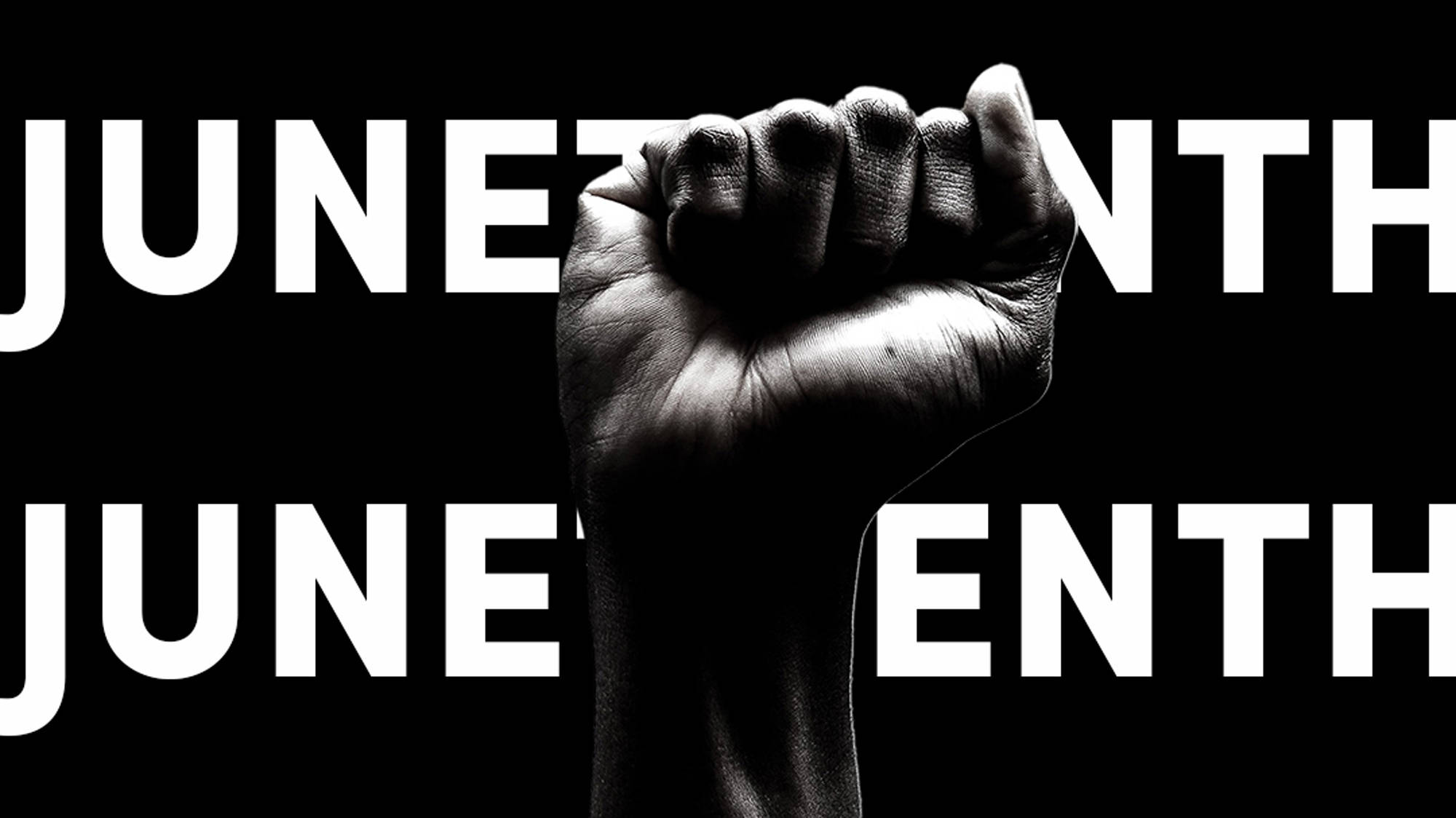 Juneteenth 桌布 壁紙 — 一張強而有力的黑白圖像，在純黑背景上展示高舉的拳頭，並以粗體白色文字寫著「JUNETEENTH」。