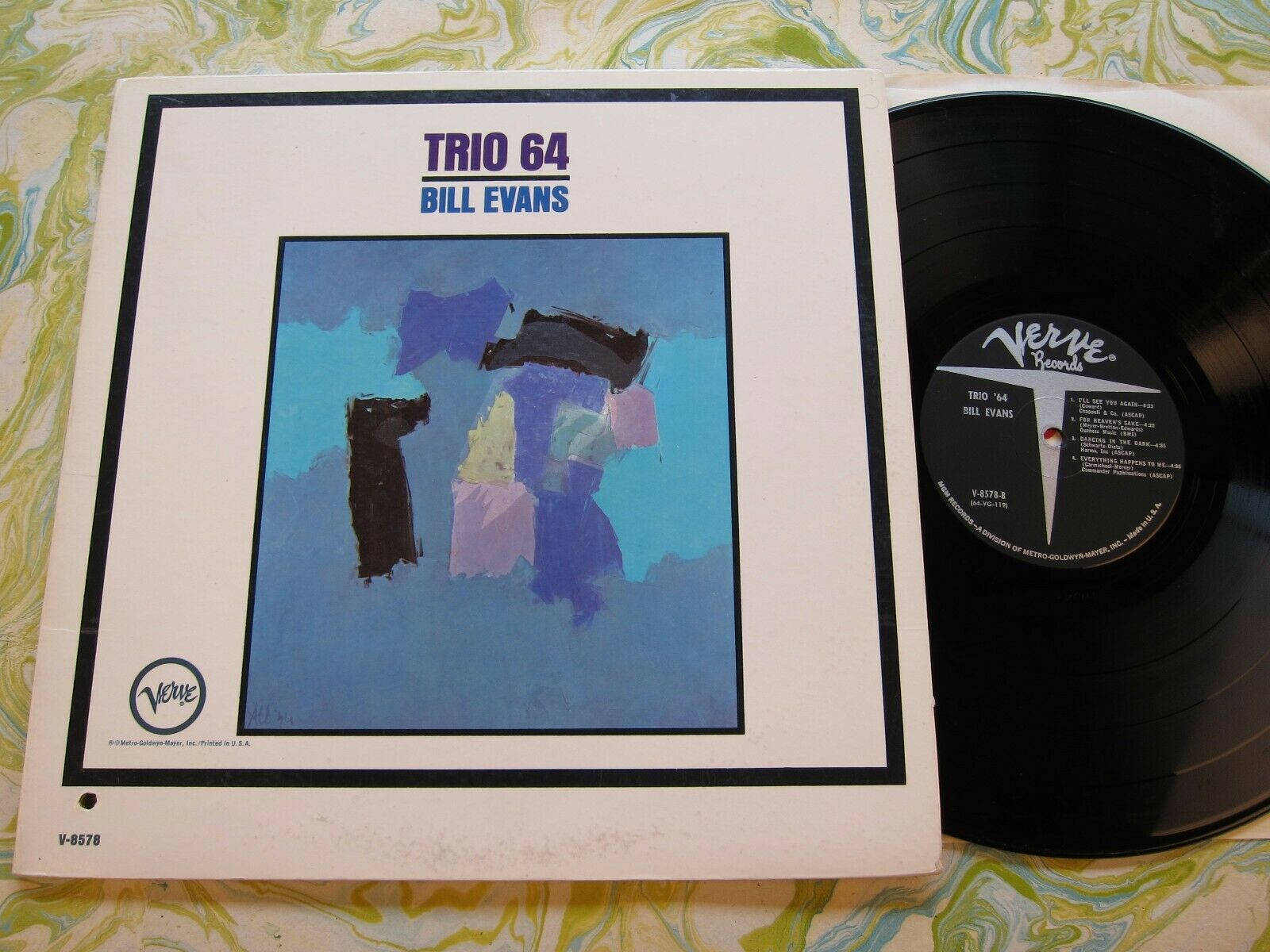 vinyl 桌布 壁紙 — 一張復古Bill Evans Trio 64黑膠唱片和專輯封面放在旋轉的綠色和白色圖案布料上。