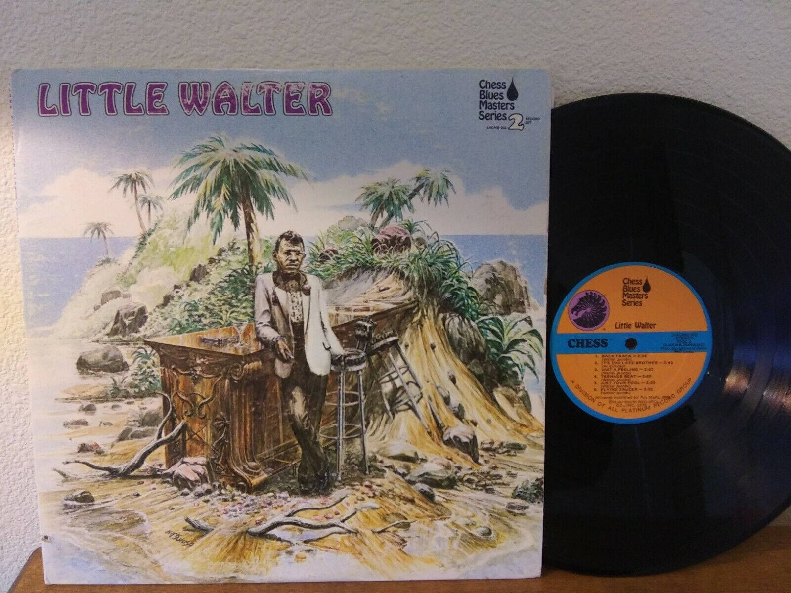 Little Walter 桌布 壁紙 — 一張復古專輯封面顯示一名身穿西裝的男子站在熱帶海灘的鄉村酒吧旁，背景有棕櫚樹和海洋。