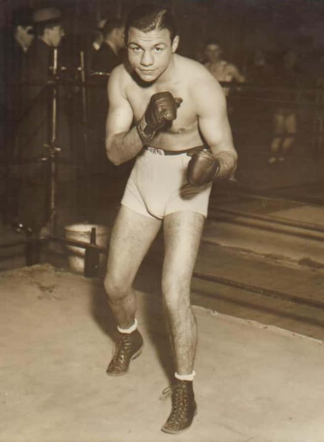 Boxing 桌布 壁紙 — 一張復古棕褐色調的照片，一名肌肉發達的拳擊手穿著白色短褲和手套，警覺地站在擂台上，背景觀眾模糊不清。