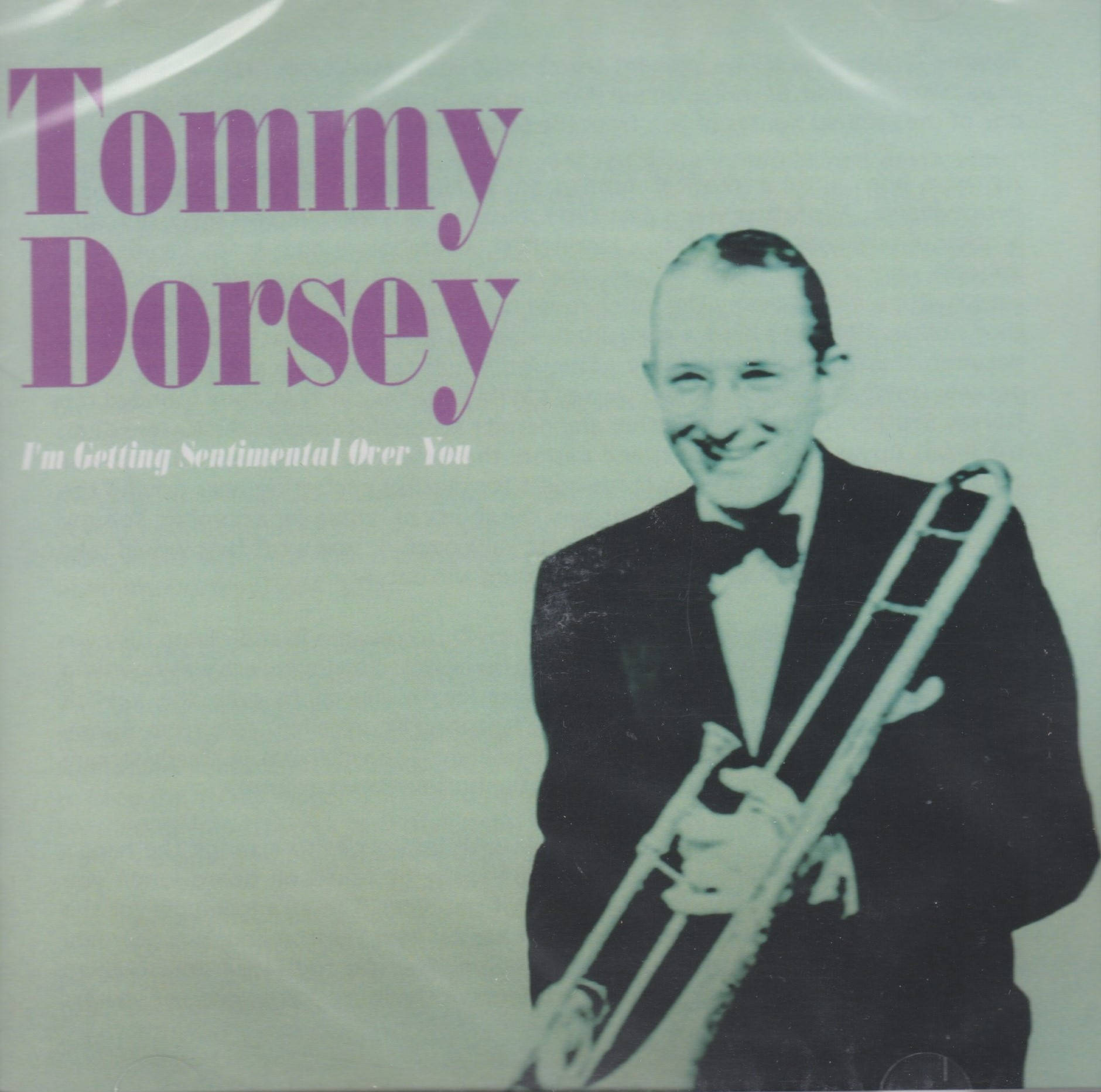 album 桌布 壁紙 — 一張復古爵士專輯封面，Tommy Dorsey 在淺綠色背景前溫暖微笑，手持長號。