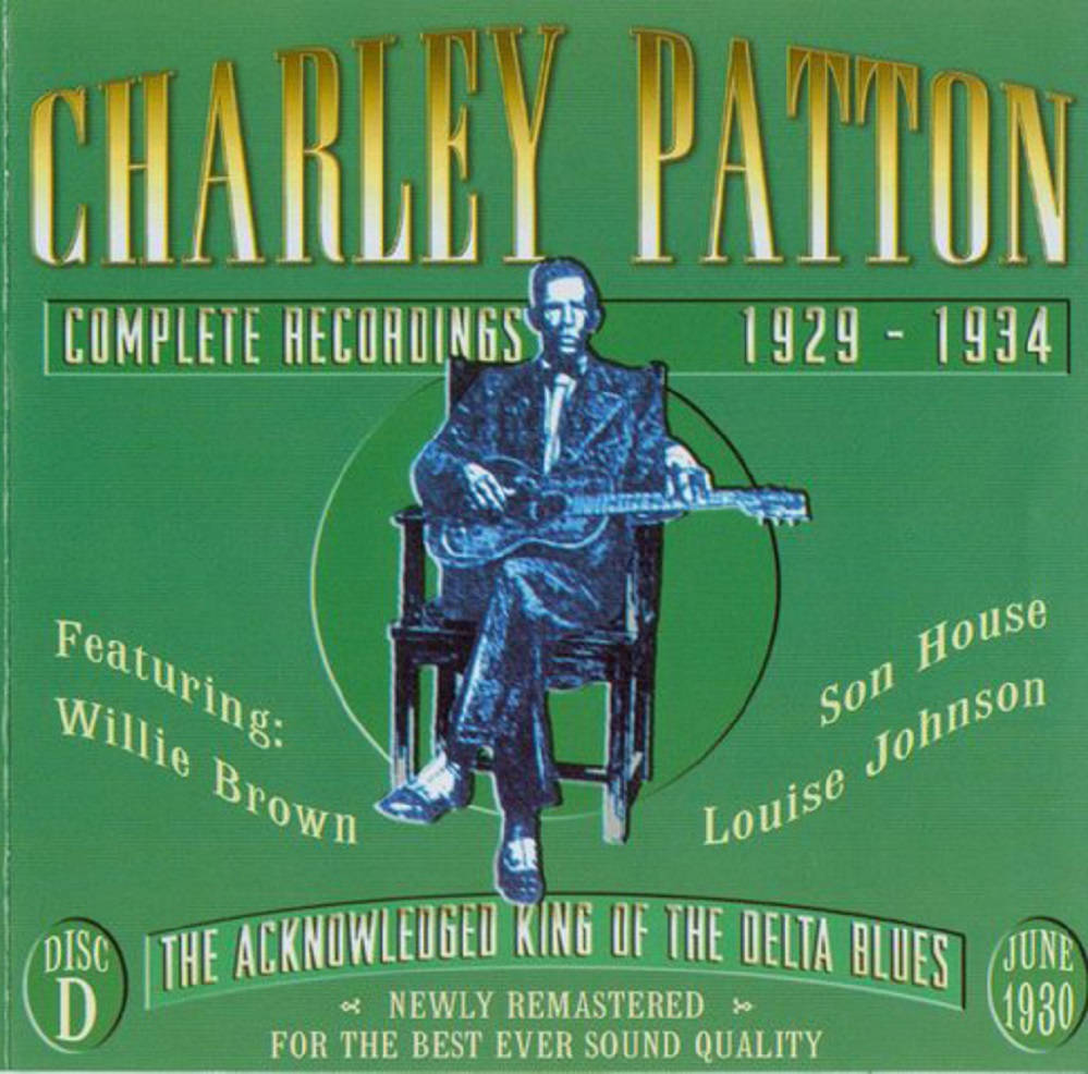 Legend 桌布 壁紙 — 一張復古綠色專輯封面，以藍色調插圖描繪 Charley Patton 坐著彈吉他，周圍環繞著描述他藍調錄音的文本。