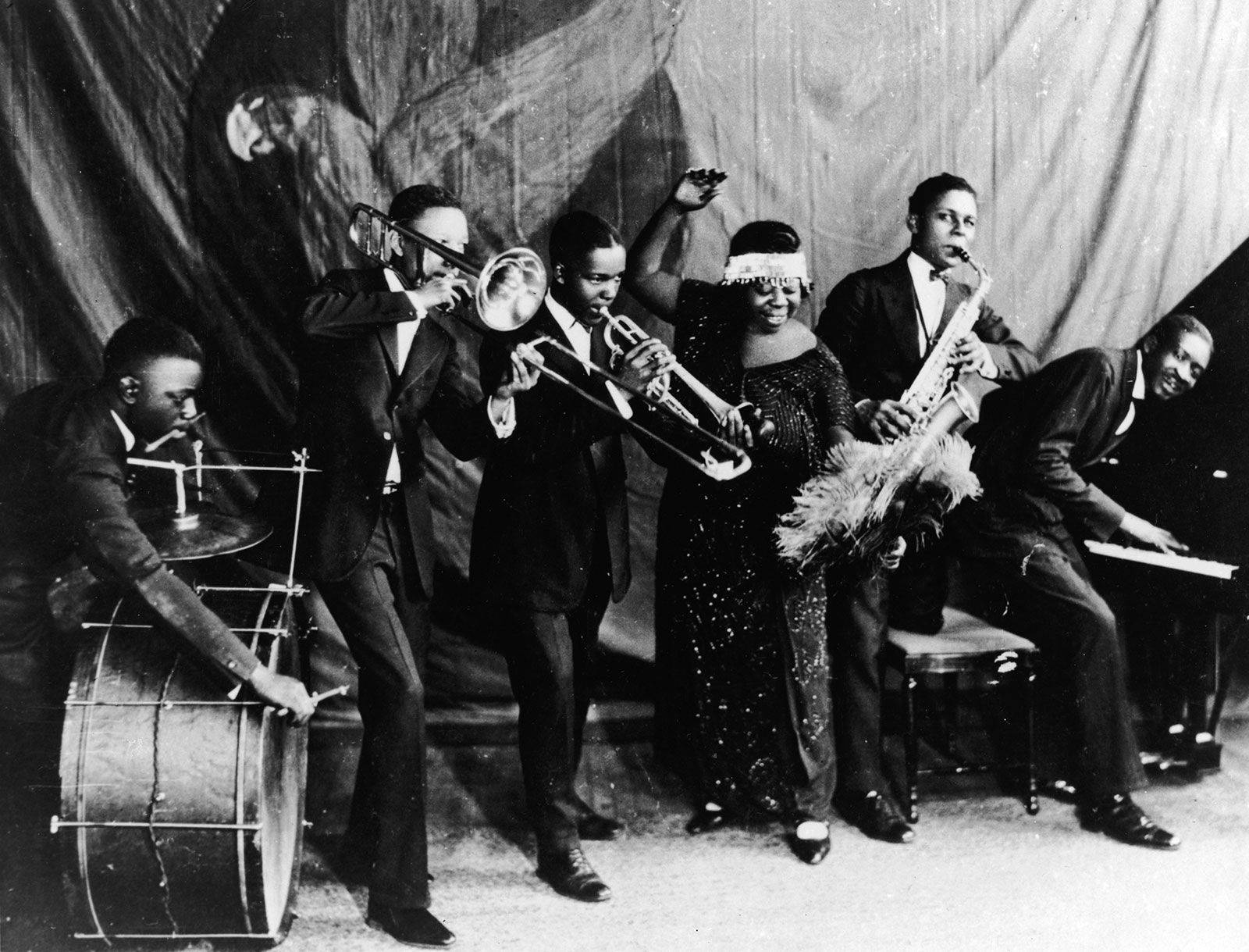 Jazz 桌布 壁紙 — 一張復古黑白照片，爵士樂隊在舞台上演奏，包括銅管樂器和鼓手。