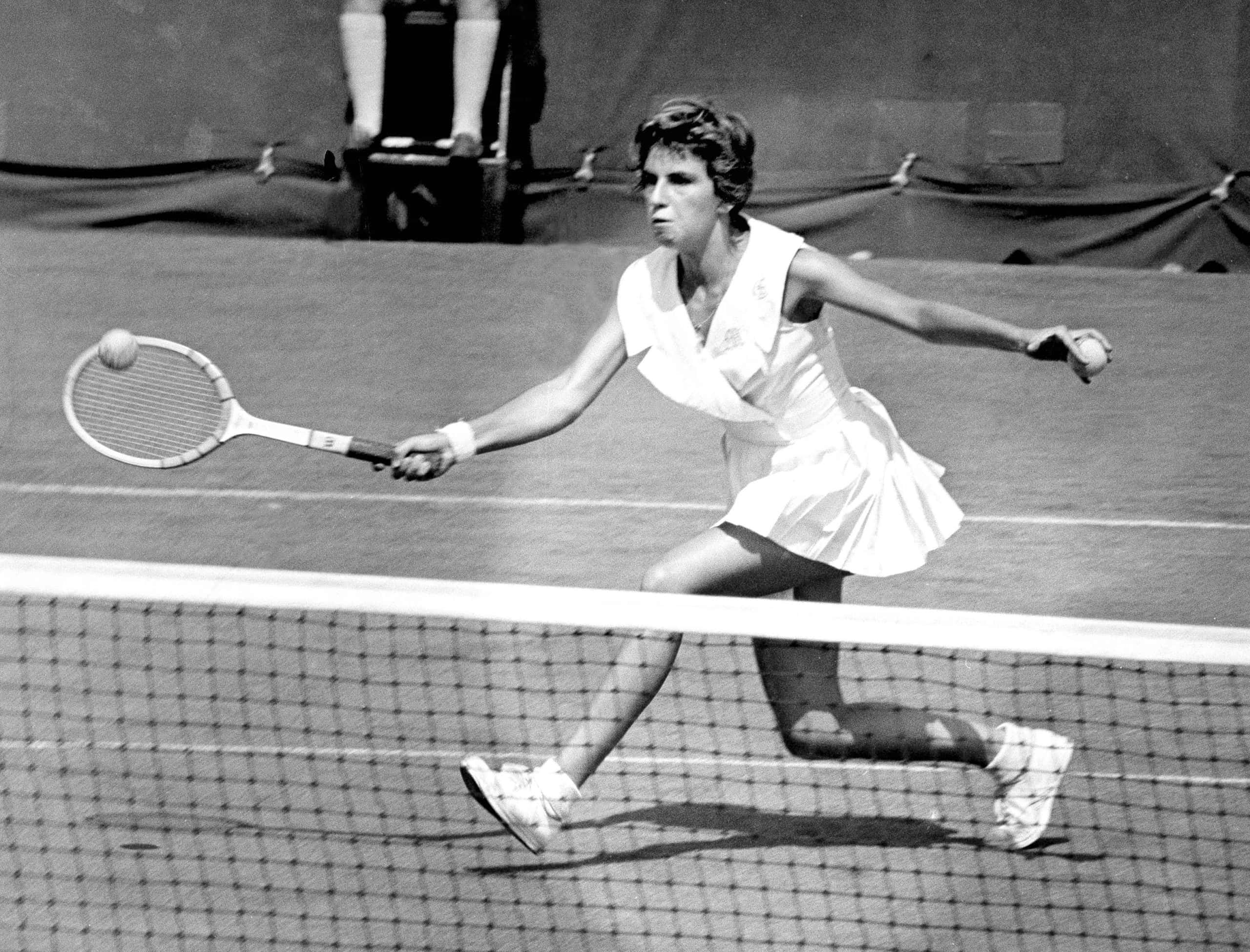 Tennis 桌布 壁紙 — 一張復古黑白照片捕捉到一名女網球運動員在網前猛力撲前的瞬間，動作激烈。