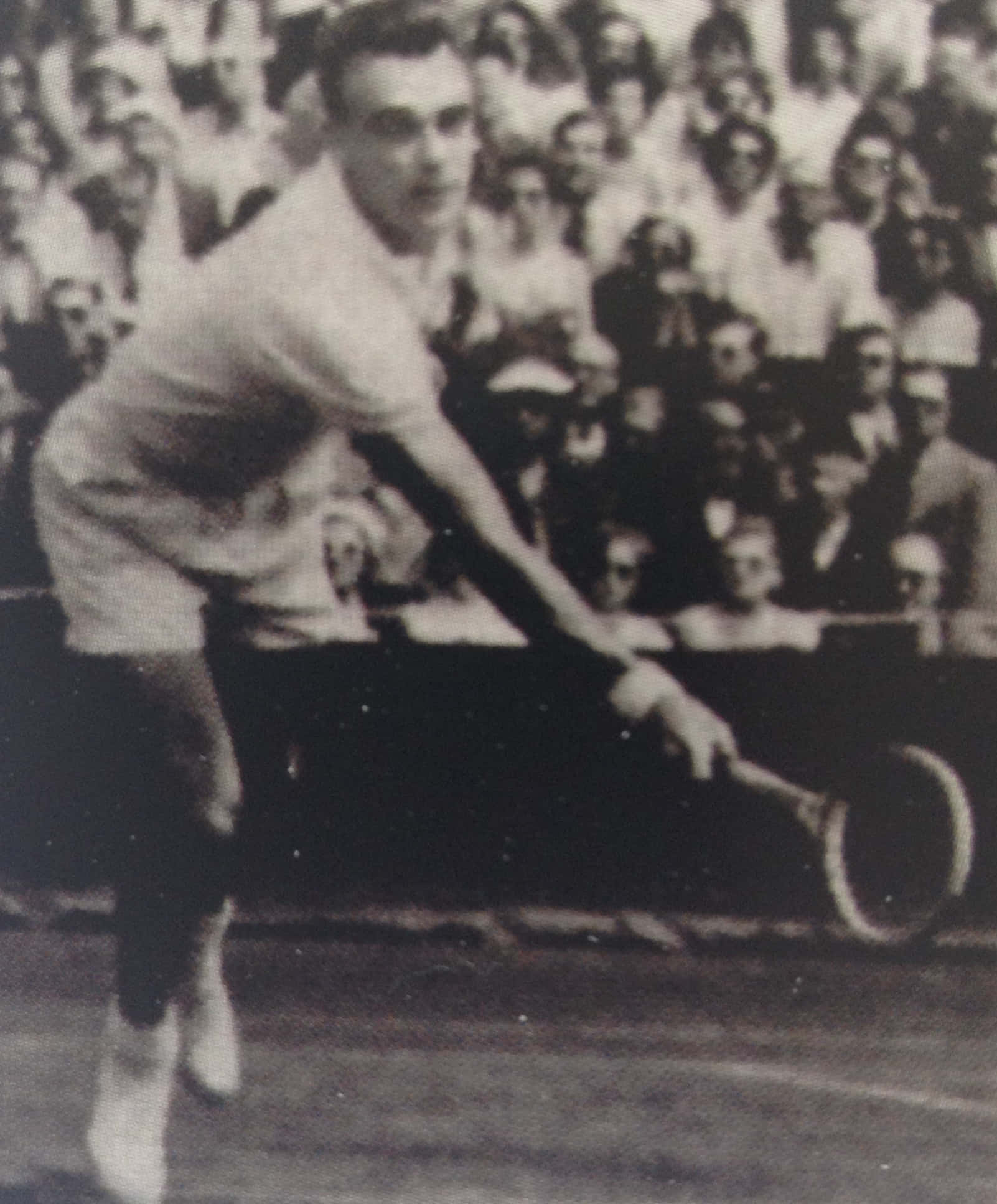 Tennis 桌布 壁紙 — 一張復古黑白照片捕捉到一名男網球運動員在草地場上揮拍，背景是模糊的人群。