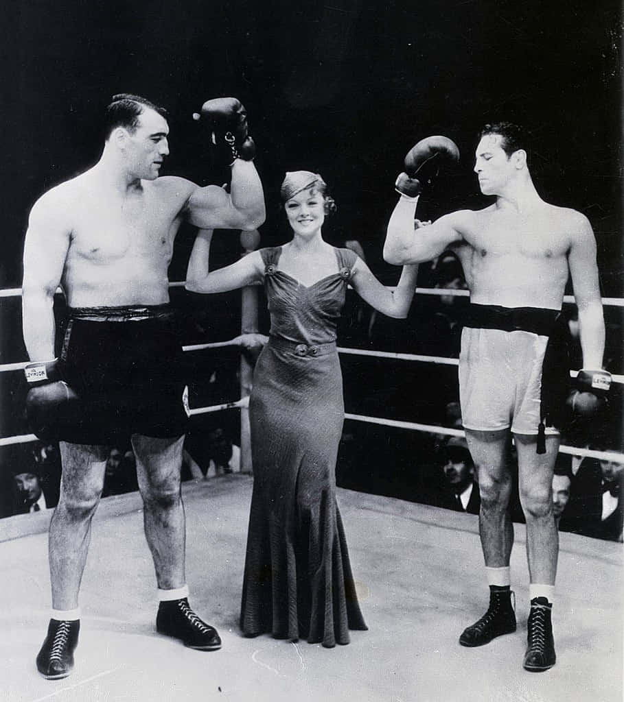 Boxing 桌布 壁紙 — 一張復古黑白照片顯示兩名拳擊手在拳擊場內夾著一位穿著長裙微笑的女性。
