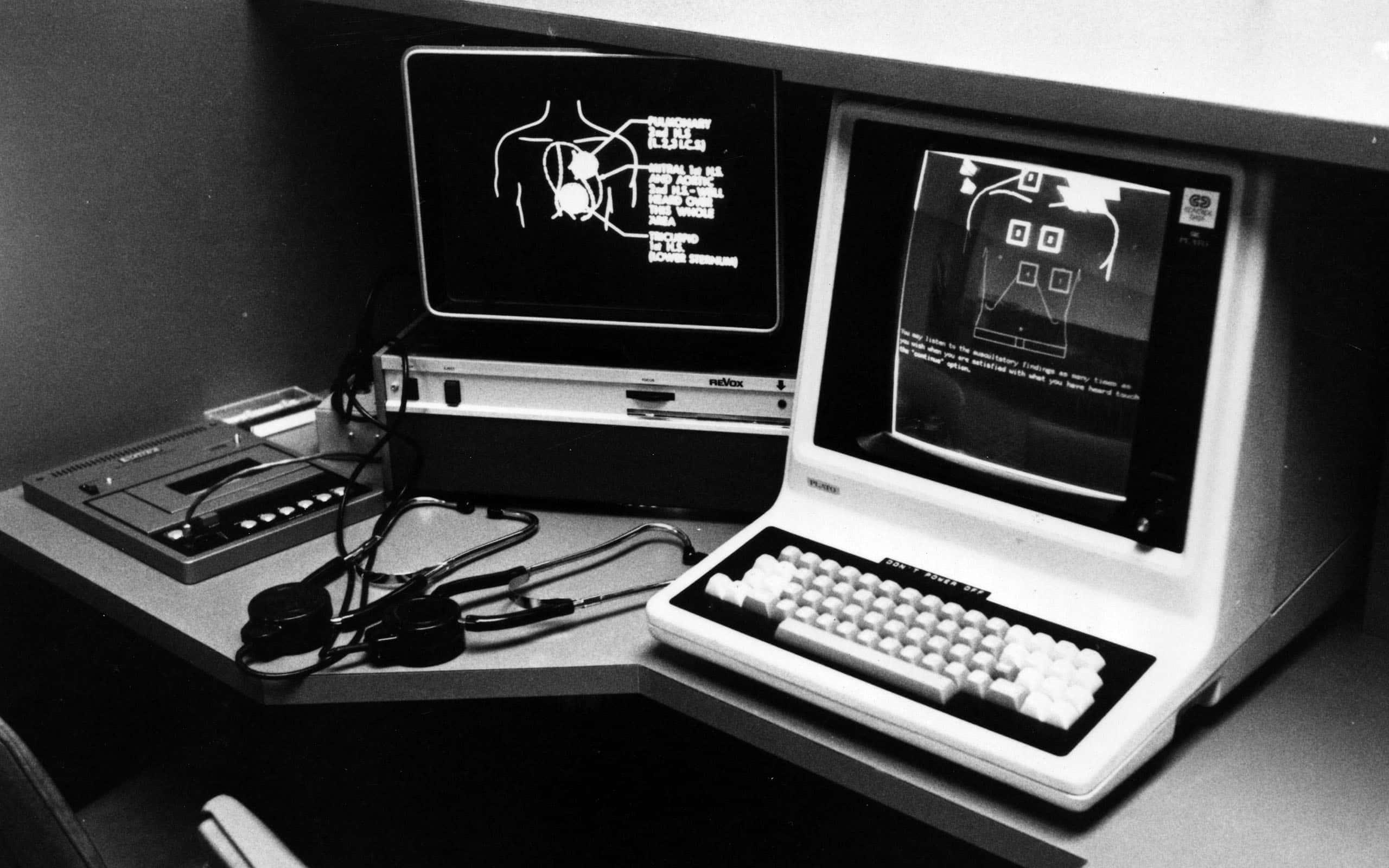 Old Pc 桌布 壁紙 — 一張懷舊黑白照片，顯示桌上兩部復古電腦，螢幕上顯示醫療圖表，附近有一個聽診器。
