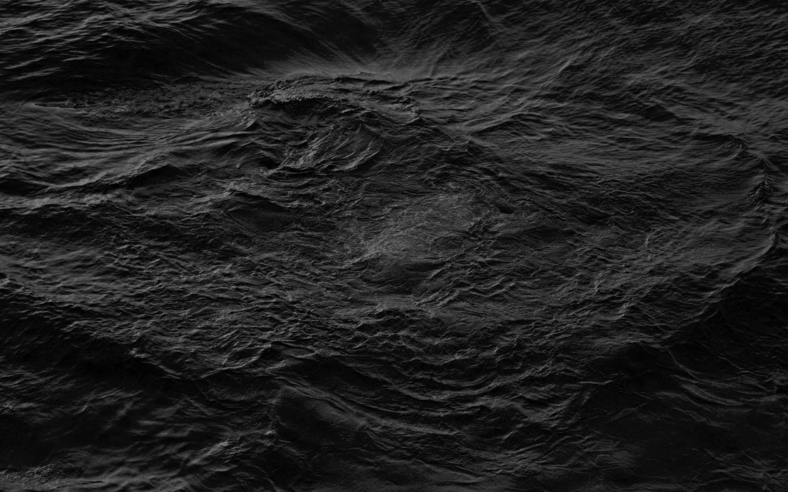Black And White Ocean 桌布 壁紙 — 一張戲劇性的特寫，呈現湍急的黑色水流，帶有旋轉的漣漪和深邃陰影，營造出陰鬱的抽象紋理。