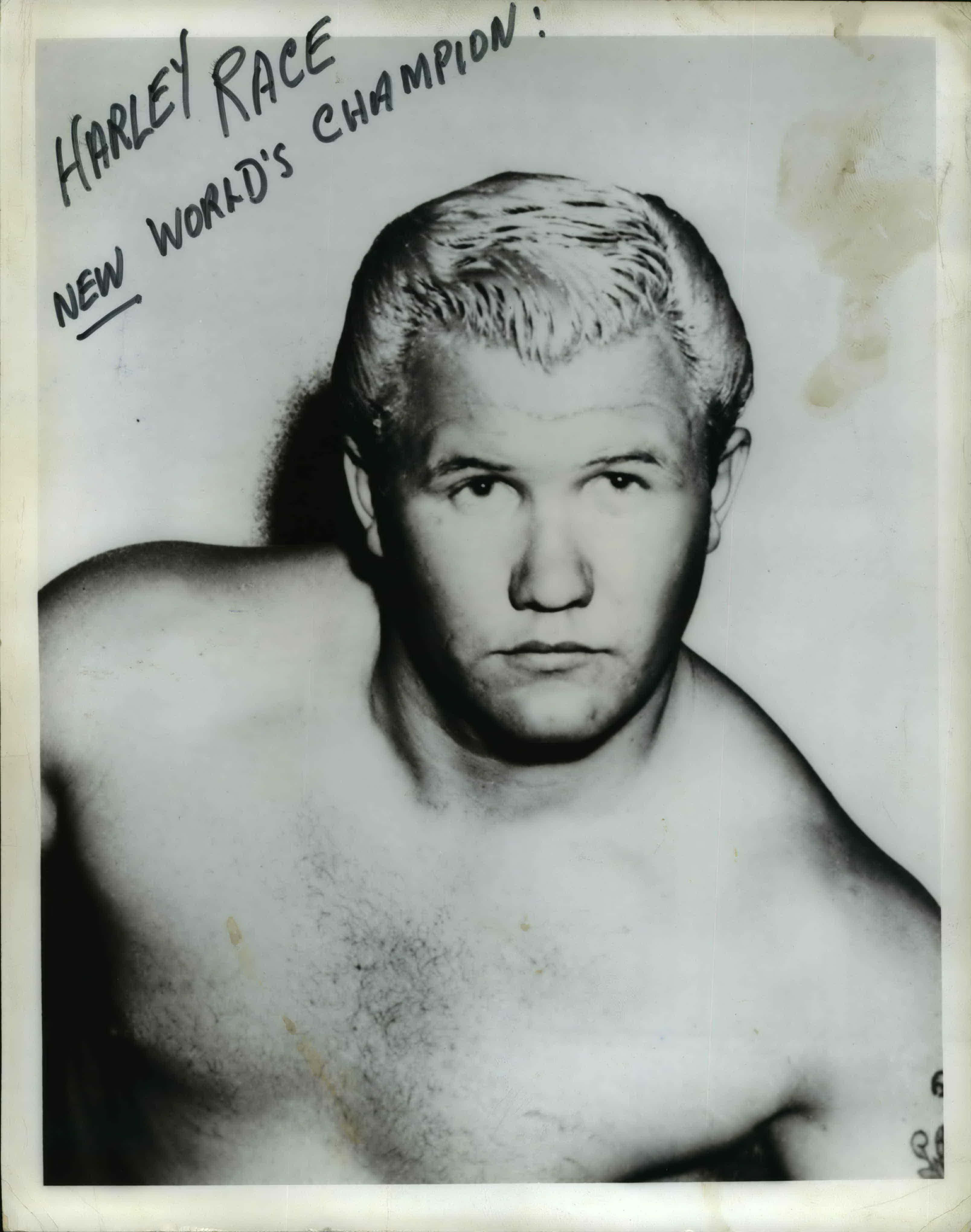 Athlete 桌布 壁紙 — 一張摔角手 Harley Race 的復古黑白肖像照，照片上手寫文字宣佈他為「New World's Champion」。