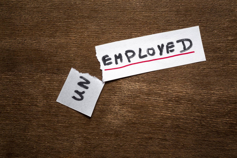 graphic art 桌布 壁紙 — 一張撕破的紙條上寫著 'EMPLOYED' 並被紅線劃過，放在木質表面上，撕破的部分露出 'UN'。